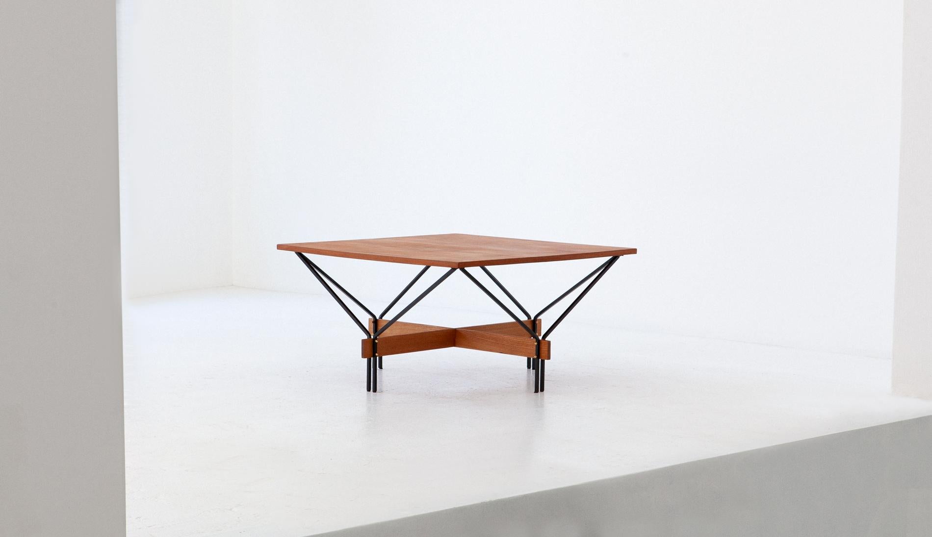 Geometrical and airy low table manufactured in Italy during the 1950s
The design is attributed to Ico Parisi
This center table has a teak square plane and geometric black enameled iron frame with brass bolts
This is a Mid-Century Modern style