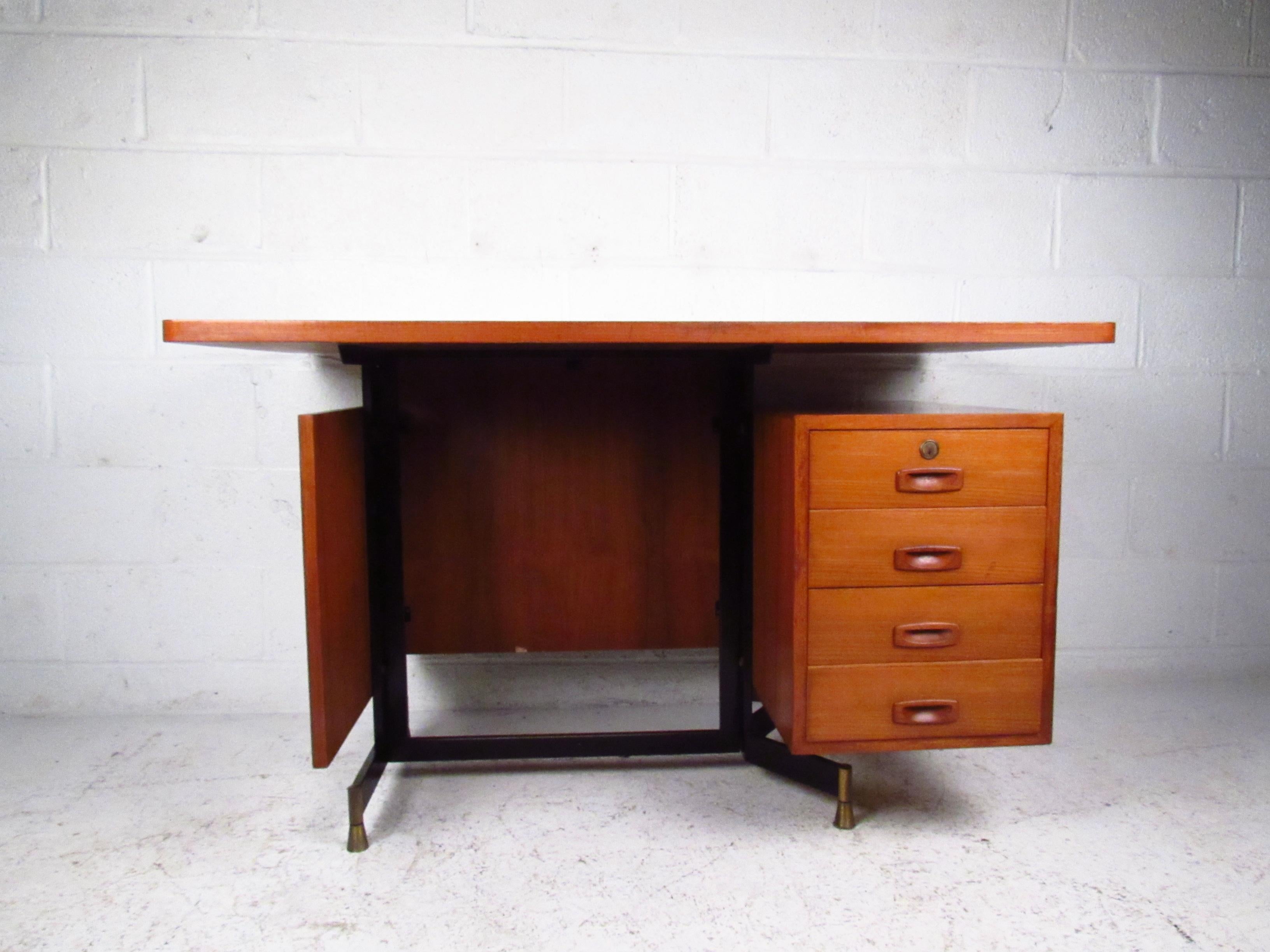 Single pedestal teak desk with floating top, four-drawer cabinet, carved recessed pulls, and metal structural frame. Please confirm item location (NY or NJ) with dealer.