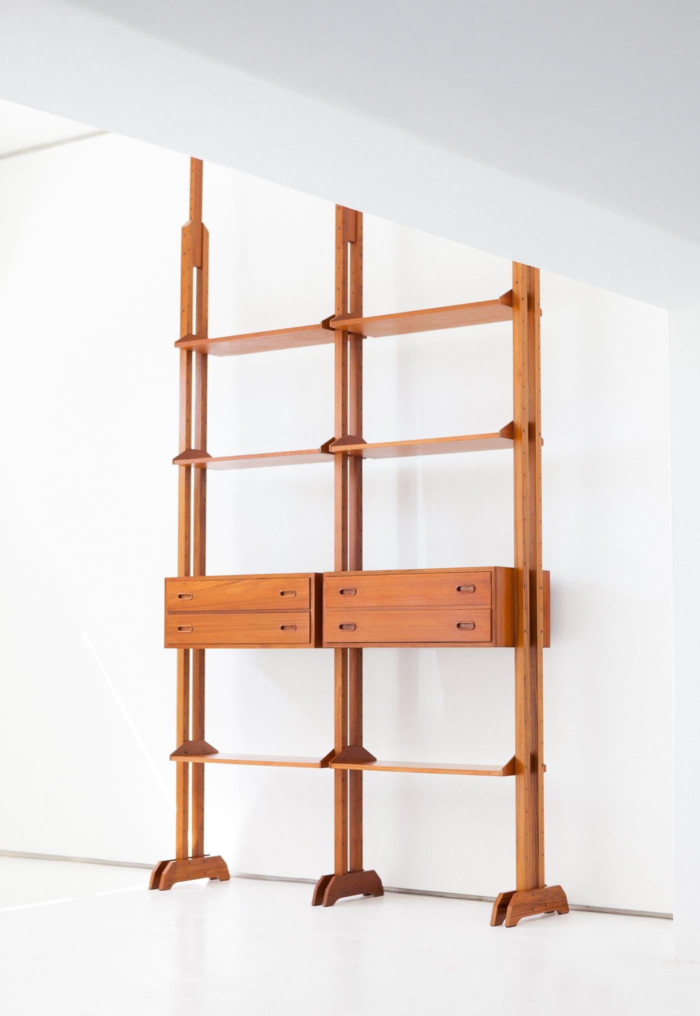 A modern bookcase, manufactured in Italy in 1950s.

The mounting of this  bookshelf is with pressure between the floor and the ceiling .
This modular shelving’s system allows you to choose where to mount the shelves and the small cabinets, but these