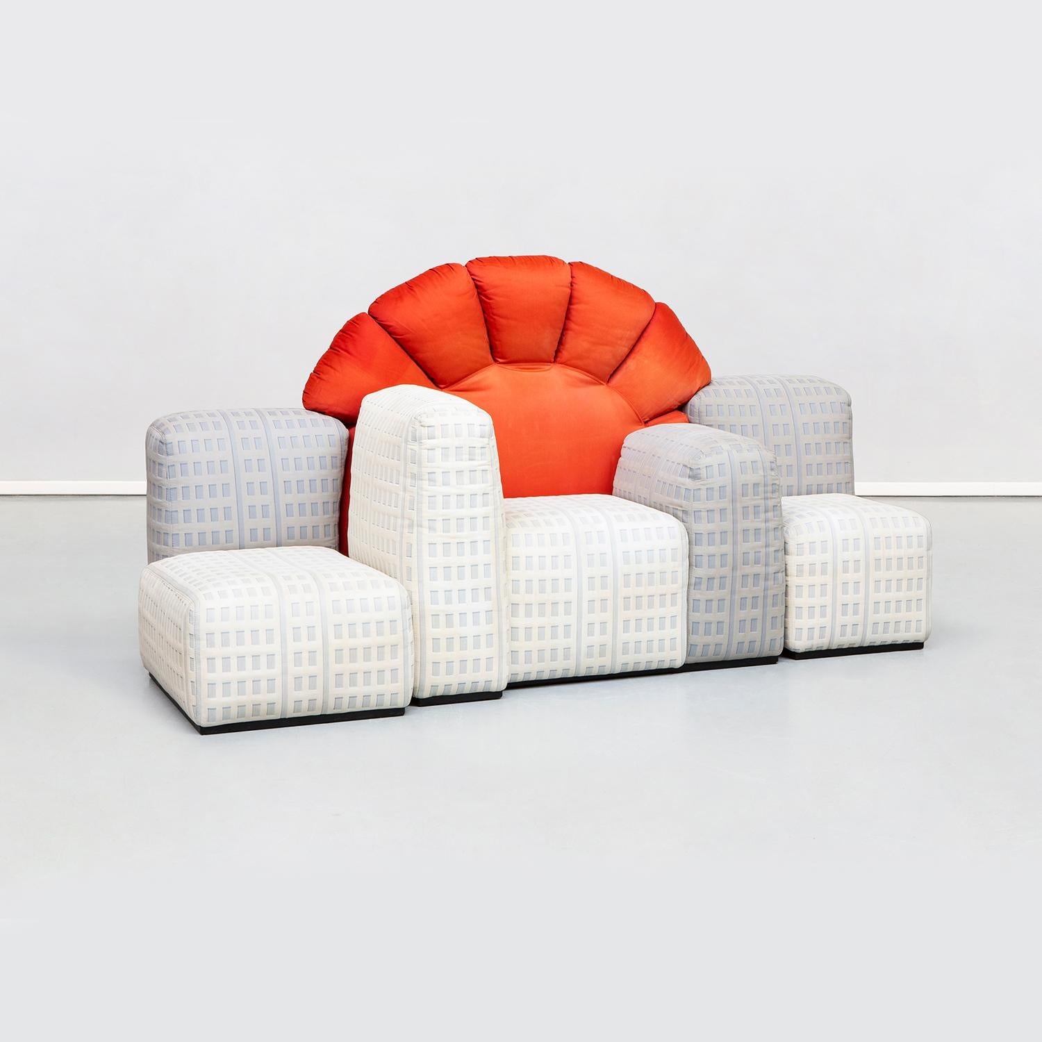Modular sofa model Tramonto a New York, made up of eight pieces between skyscrapers and sun. The padded skyscrapers act as seats and armrests and backrests and are covered in a fabric with a relief texture, which combines light with dark, recreating