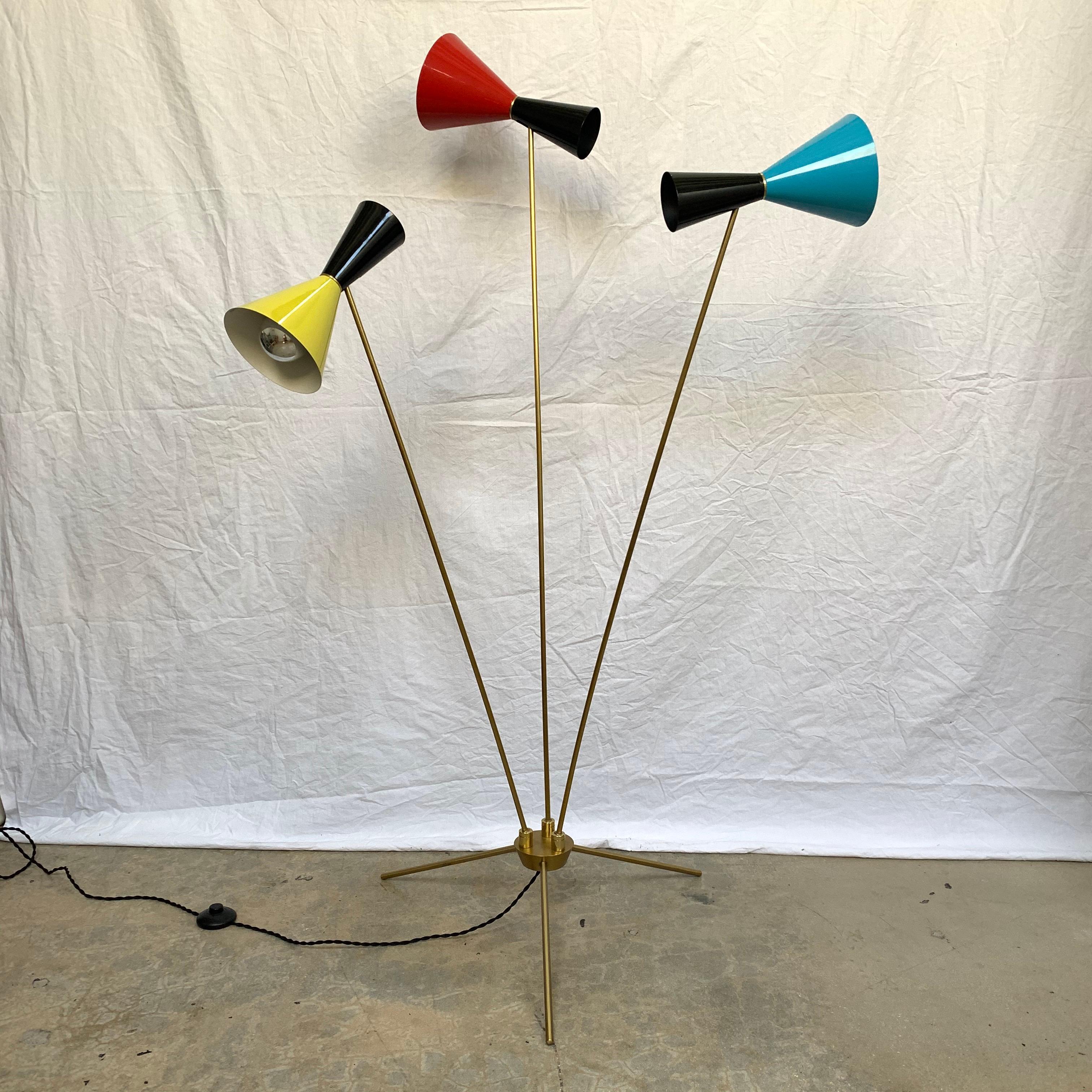 Unique sculptural articulating and adjustable 3-arm and 3-leg tripod floor lamp rendered in patinated brass with lacquered cone shade heads in Classic primary Italian colors, red, yellow, and blue, with a silk cord and foot switch, in the style