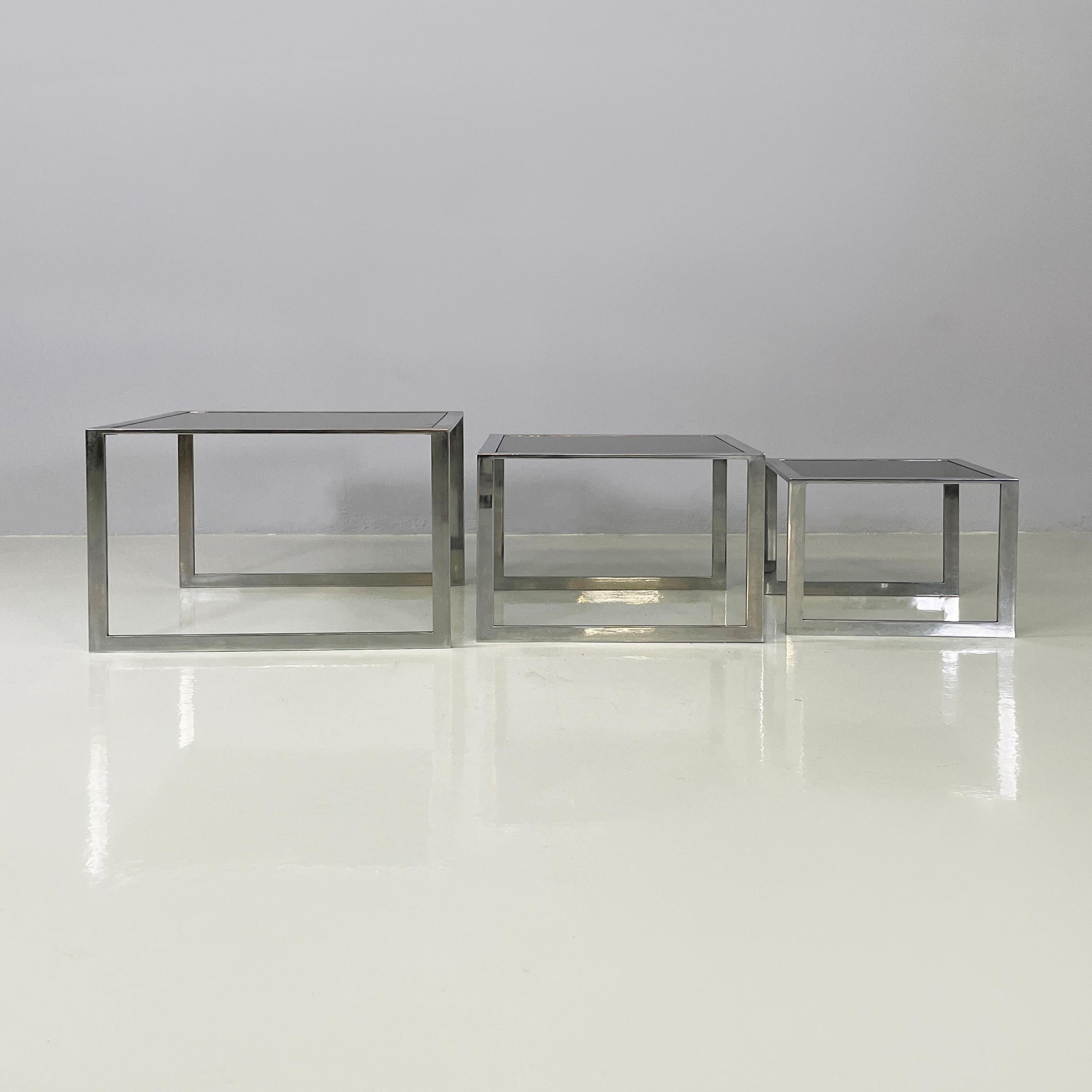 Italienisches modernes Trio aus Couchtischen aus Rauchglas und Metall, 1980er Jahre
Trio von fantastischen Couchtischen mit quadratischer Rauchglasplatte. Die Struktur besteht aus verchromten Metallstreifen.
1980s.
Guter Zustand, leichte Spuren auf