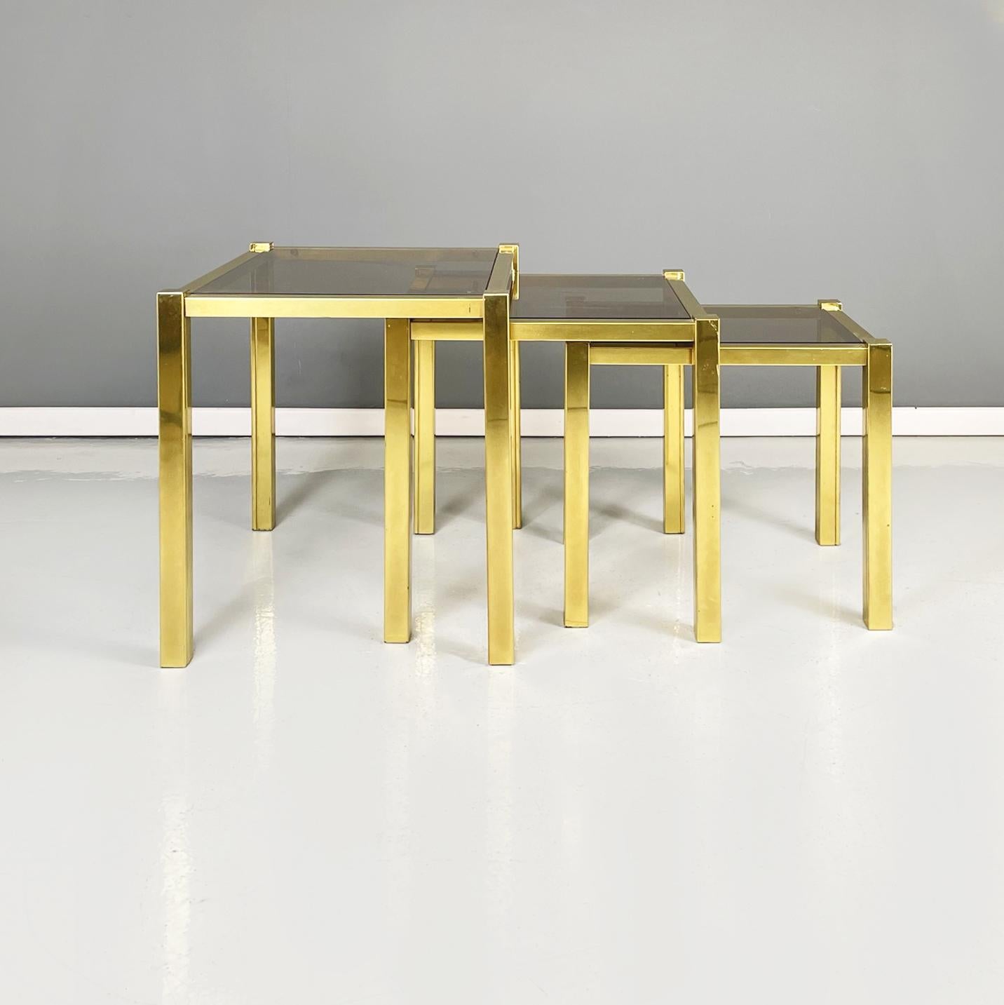Italian modern Trio of coffee tables in brass and smoked glass, 1970s
Trio of coffee tables with rectangular tops in smoked glass. The square section structure is in brass. The tables can be inserted one inside the other.
1970s 
Very good