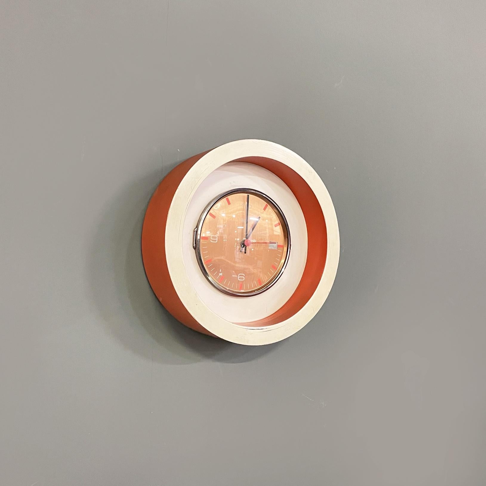 Italian modern Wall clock in white and orange wood and metal by Astra, 1980s
Round wall clock with thick and protruding wooden frame painted in white and orange. The round dial is in copper-colored metal with black hands. The plastic part above the