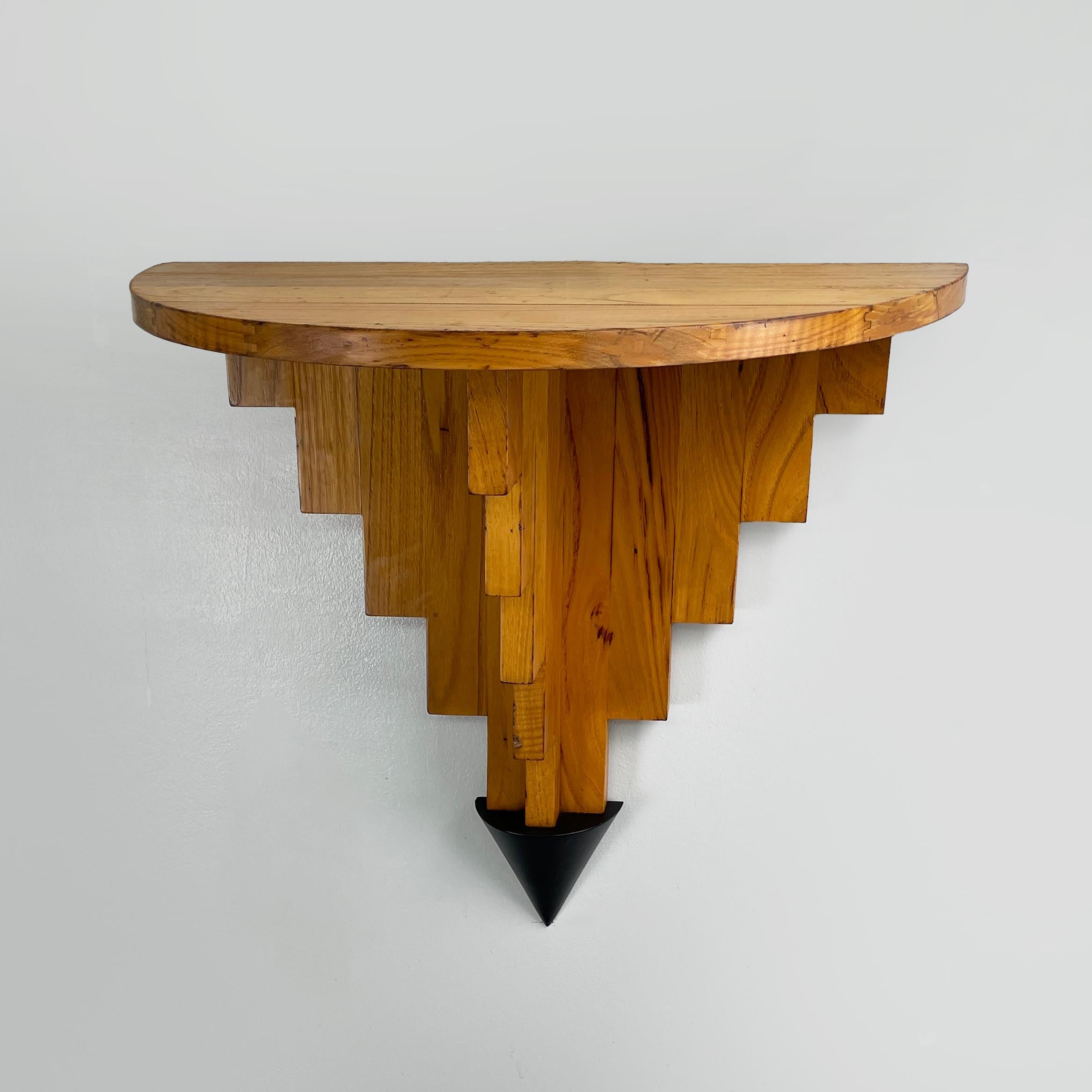 Italienisches modernes geometrisches Wandregal aus Holz, modern, 1980er Jahre
Modernes italienisches Wandregal mit halbrunder Platte, komplett aus Holz. Die dreieckige Struktur, die die Spitze trägt, besteht aus Holzleisten, die in einem schwarzen
