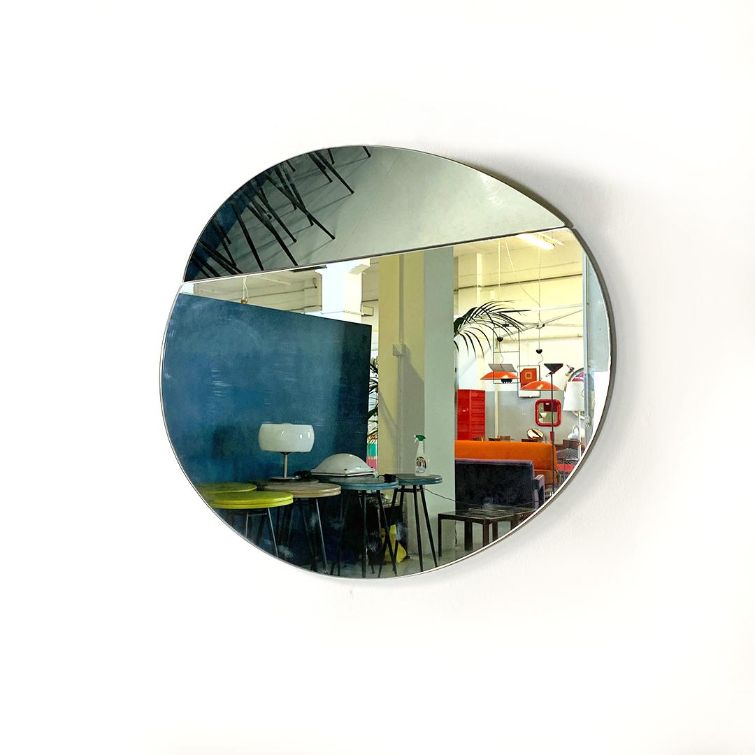 Miroir mural elliptique moderne italien avec pli dans la partie supérieure par Hiroyuki Toyoda pour Simon Gavina, 1982.
Miroir modèle Iseo de forme elliptique, avec un volet dans la partie supérieure du verre qui crée un jeu de reflets original et
