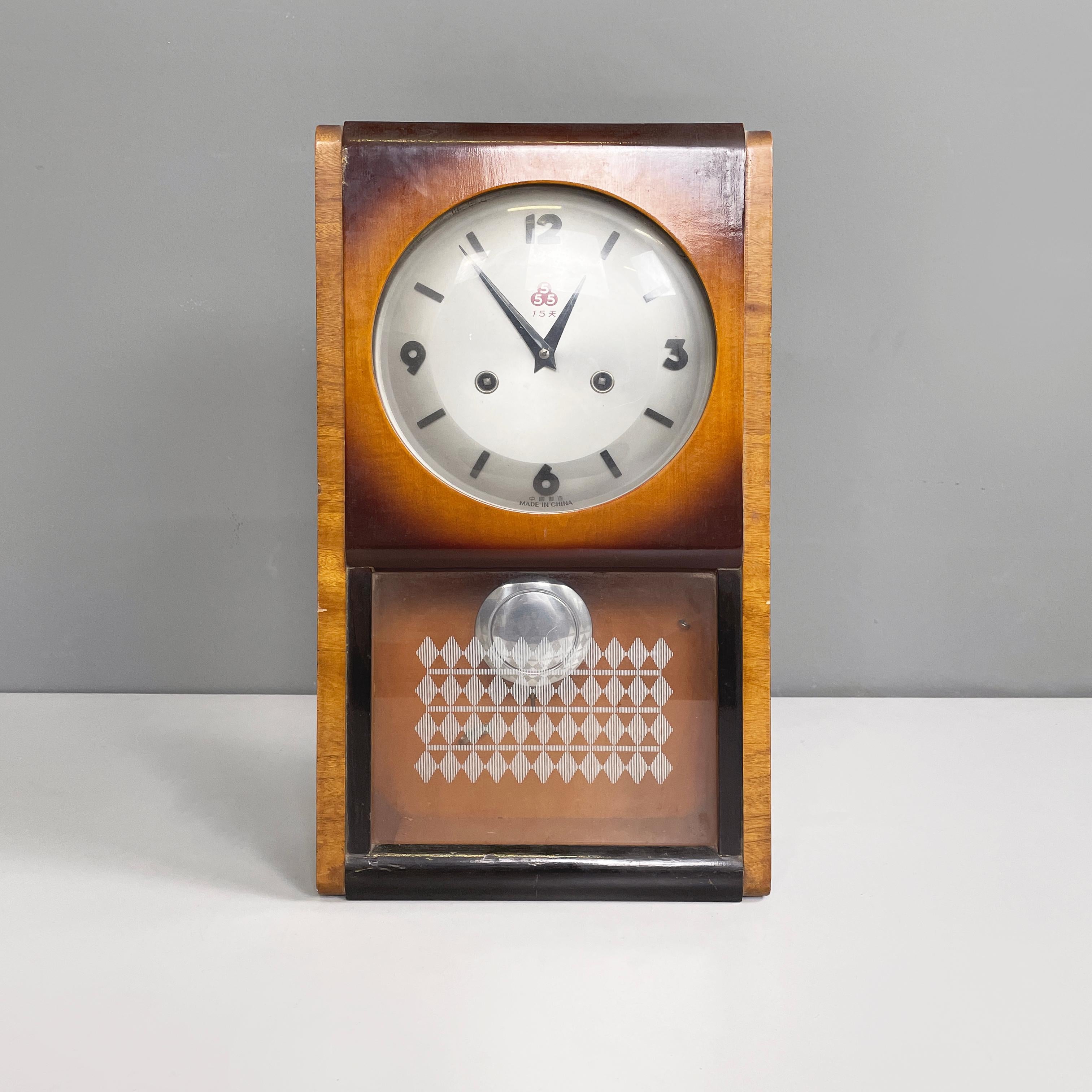 Italian modern Wall or table pendulum clock by 555 Shanghai in wood, metal and glass, 1980s
Wall or table pendulum clock with square wooden structure in different shades. On the front it has a door in wood and glass, stopped by a lateral metal hook.