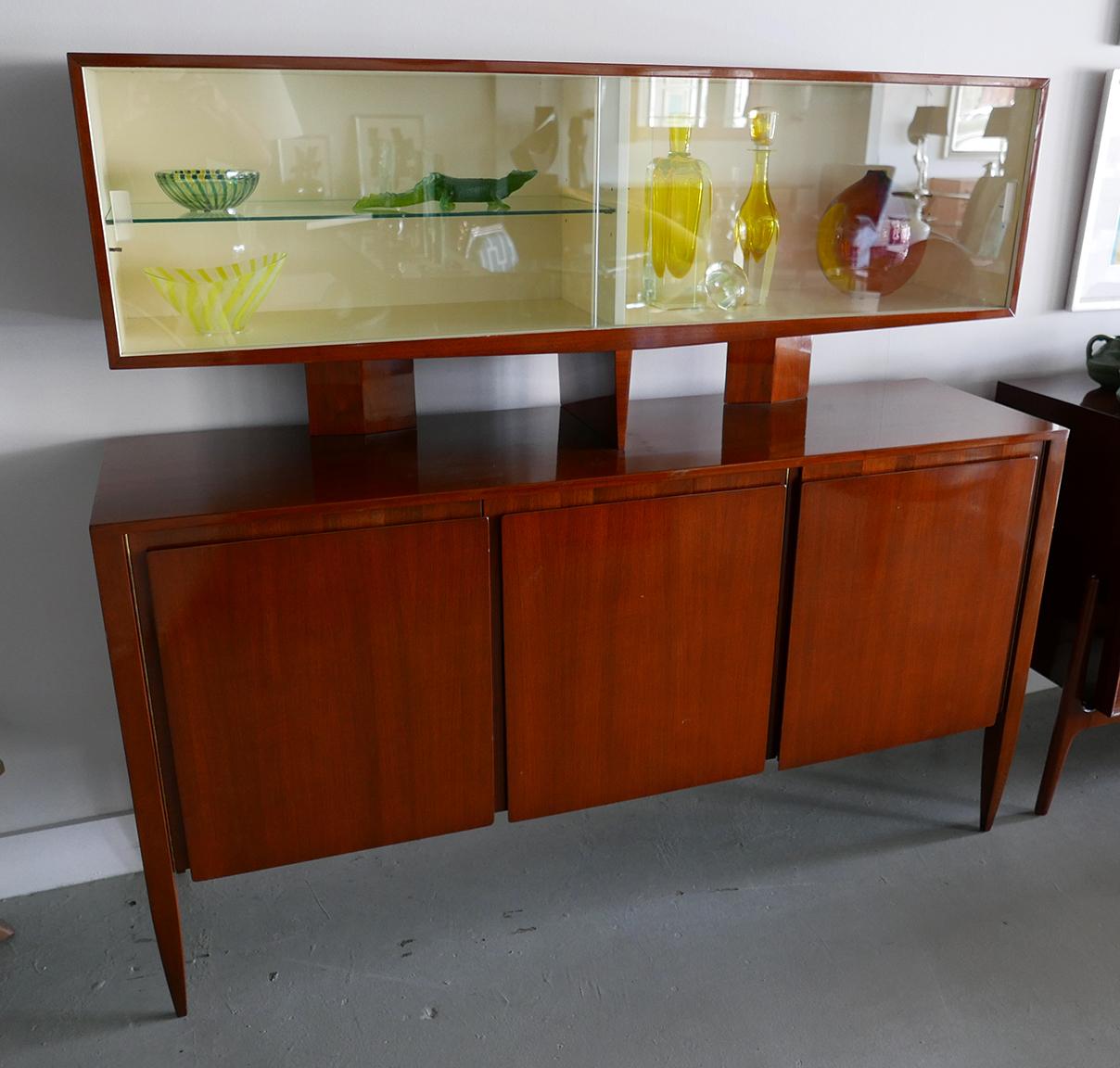 Italian Modern 2-Tier Cabinet by Gio Ponti for M. Singer & Sons. Three-door cabinet with interior double-wide drawers. One door opens to reveal open shelf storage. Up top is a floating display cabinet with white painted interior and sliding glass