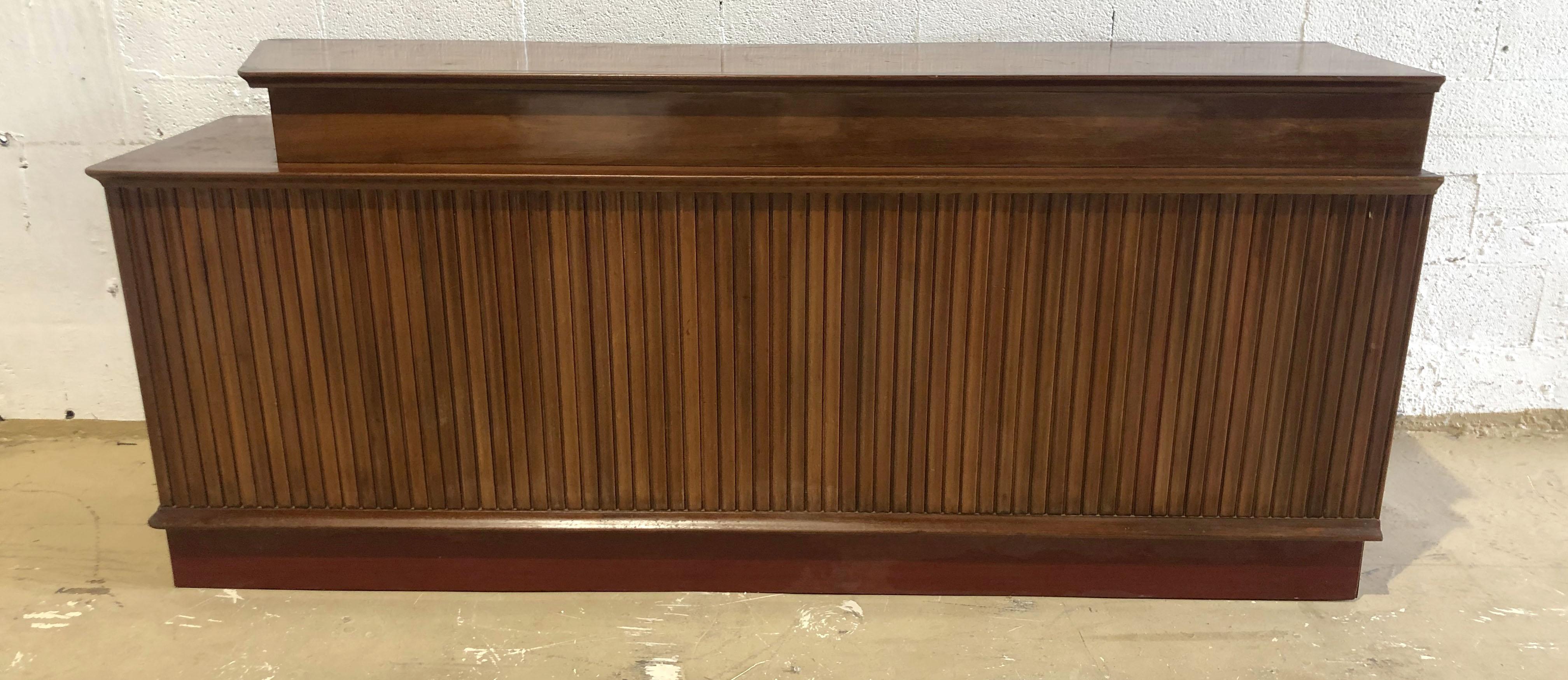 Rare room divider/ free standing credenza/ buffet/ bar/ finished on all sides- one side with 3 doors and geometric relief cut outs on the doors- the reverse side with reeded fluted motif- the top with 2 levels.