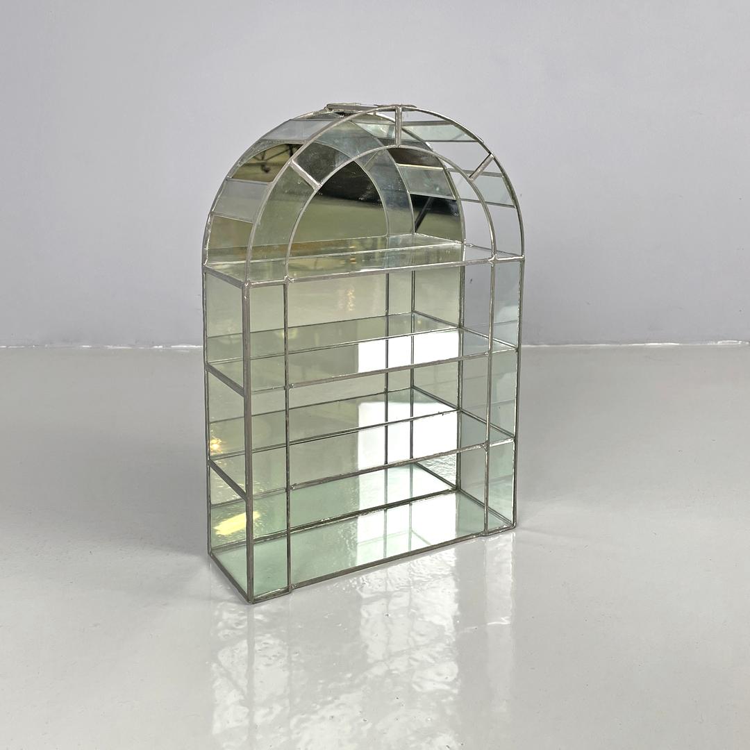 Italian modern welded glass and mirror display with three shelves, 1980s
Small transparent glass display case with mirrored background. The upper part is semicircular, the structure is composed of rectangular glass parts welded together with silver