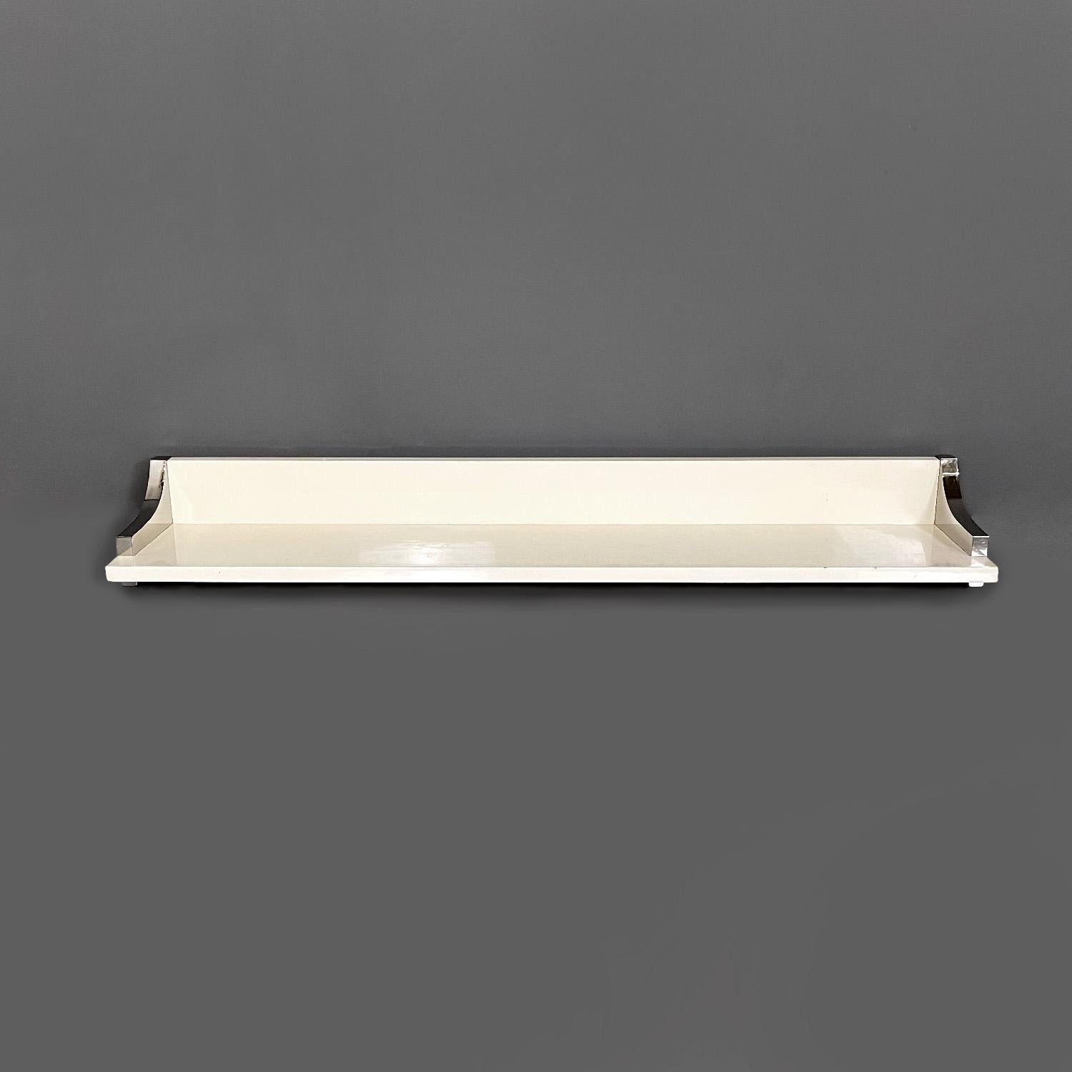 Italian modern white lacquered wood and chromed metal shelf by D.I.D., 1980s
Rectangular shelf, the structure is in white lacquered wood with a glossy finish. On both sides there is a decorative chromed metal covering that follows the trapezoidal