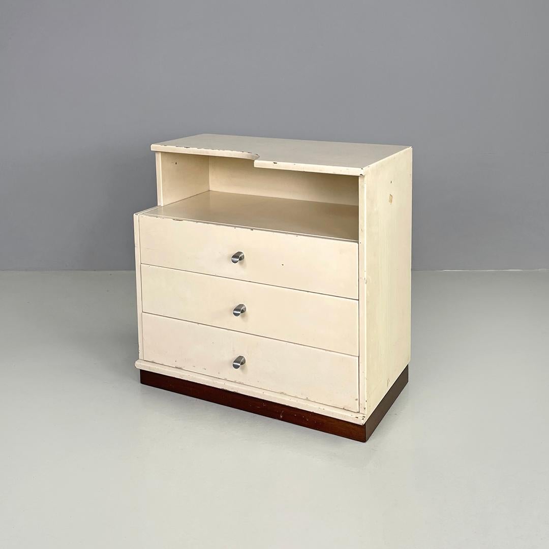 Italian modern white wooden bedside table with shaped top, 1980s
Bedside table with rectangular base in white painted wood. The top has a curved decorative shape, under the top there is a space with a support surface and three drawers with metal