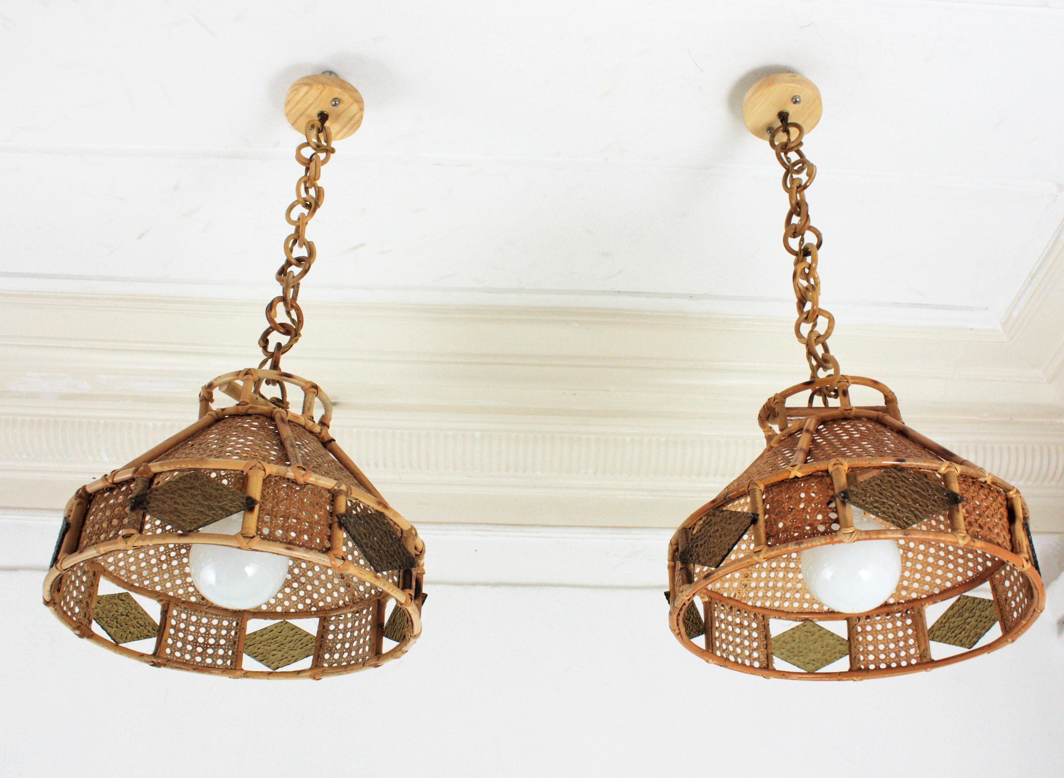 Rare Mid-Century Modern woven wicker wire and rattan pendant lamps / lanterns with textured glass rhombus, Italy, 1950s-1960s.
The woven wicker conic shades of these lamps are accented by textured rhombus shaped amber glasses. They hang from a