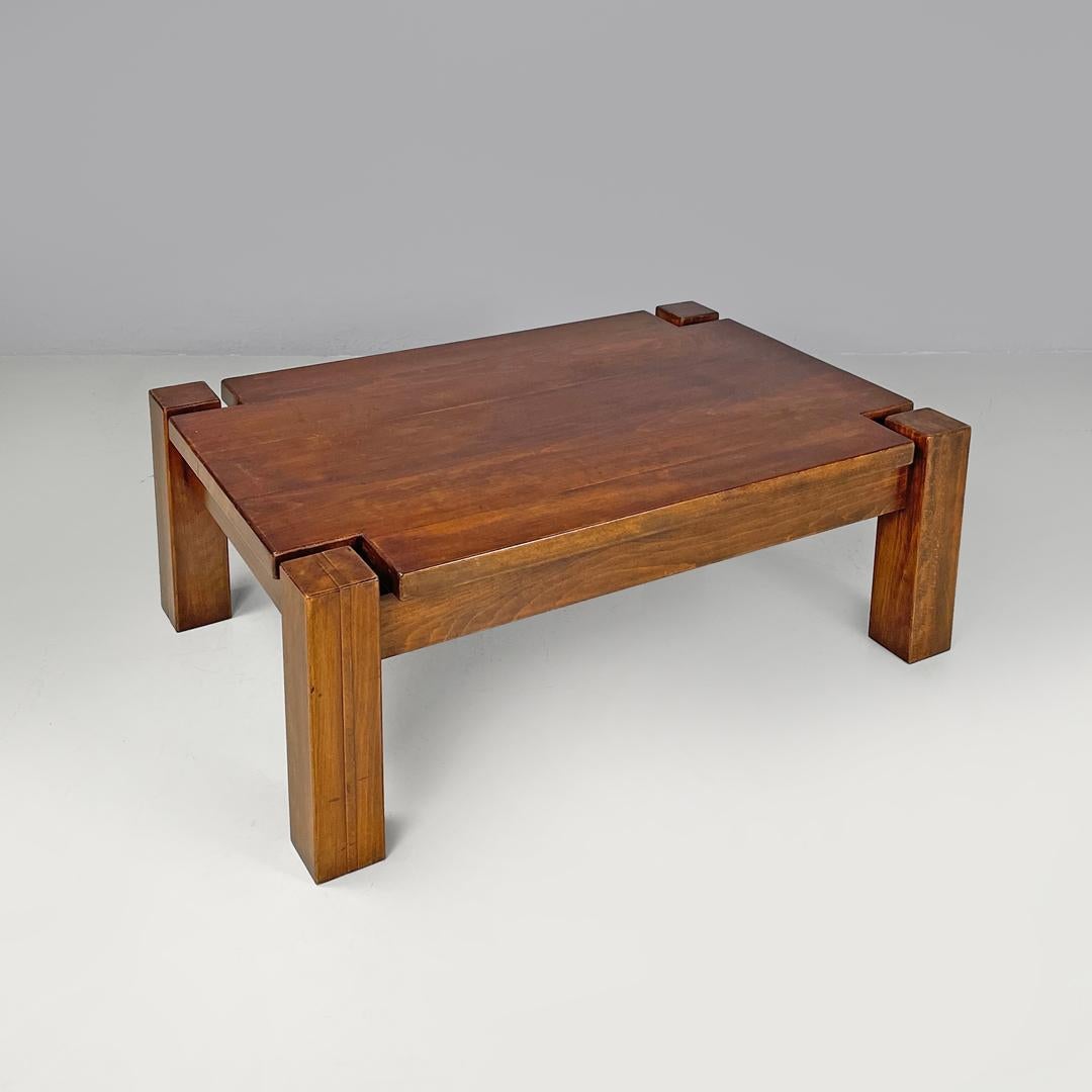 Italian modern wooden coffee table with geometric lines and squared legs, 1970s
Rectangular coffee table entirely made of wood. The structure has geometric lines, the four square-section legs are located at the corners of the top and act as