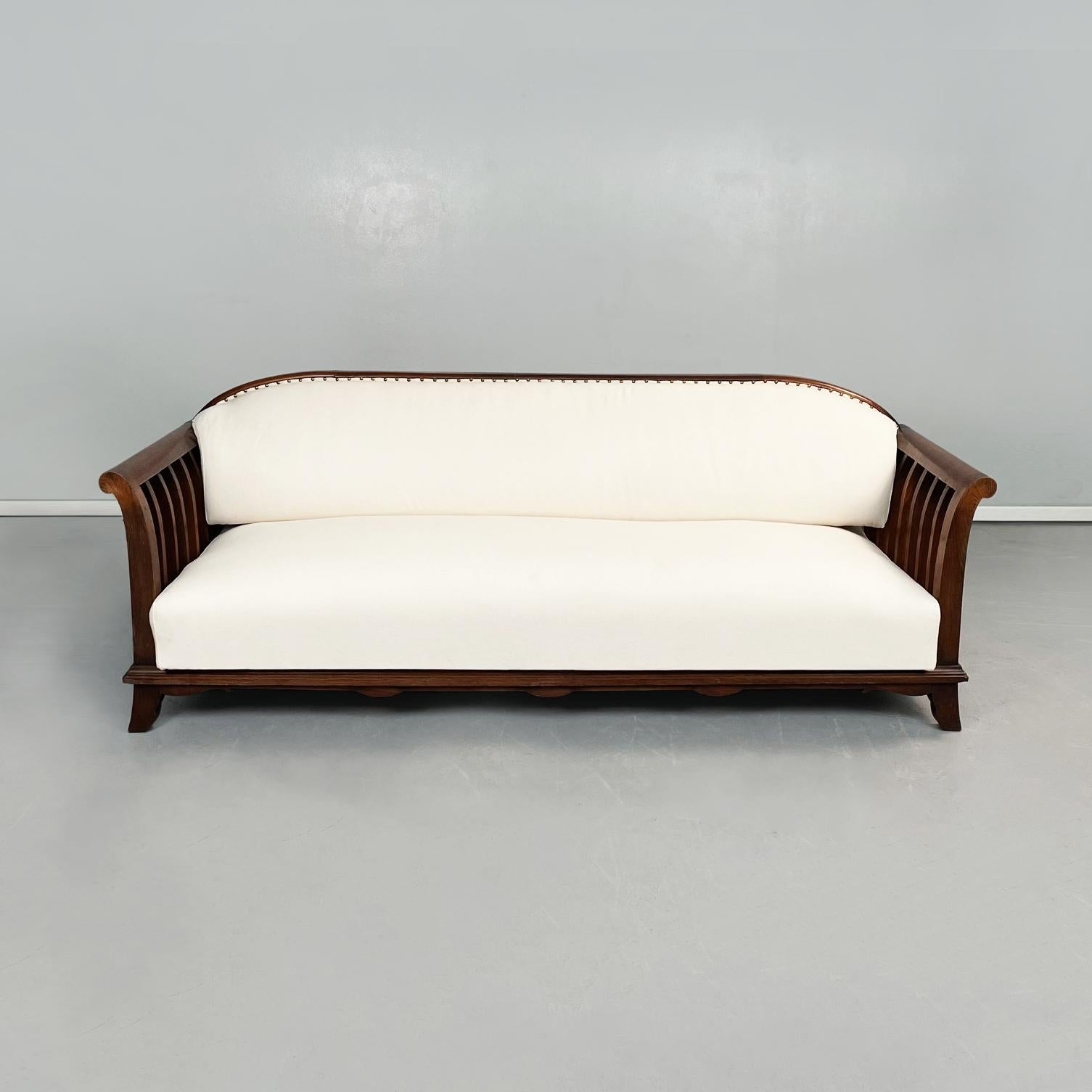 Italian modern Wooden sofa with white fabric, 1940s
A sofa with wooden structure. The sofa has a rectangular seat and a rectangular backrest with rounded upper corners, both padded and upholstered in white fabric. The wooden armrests are slightly