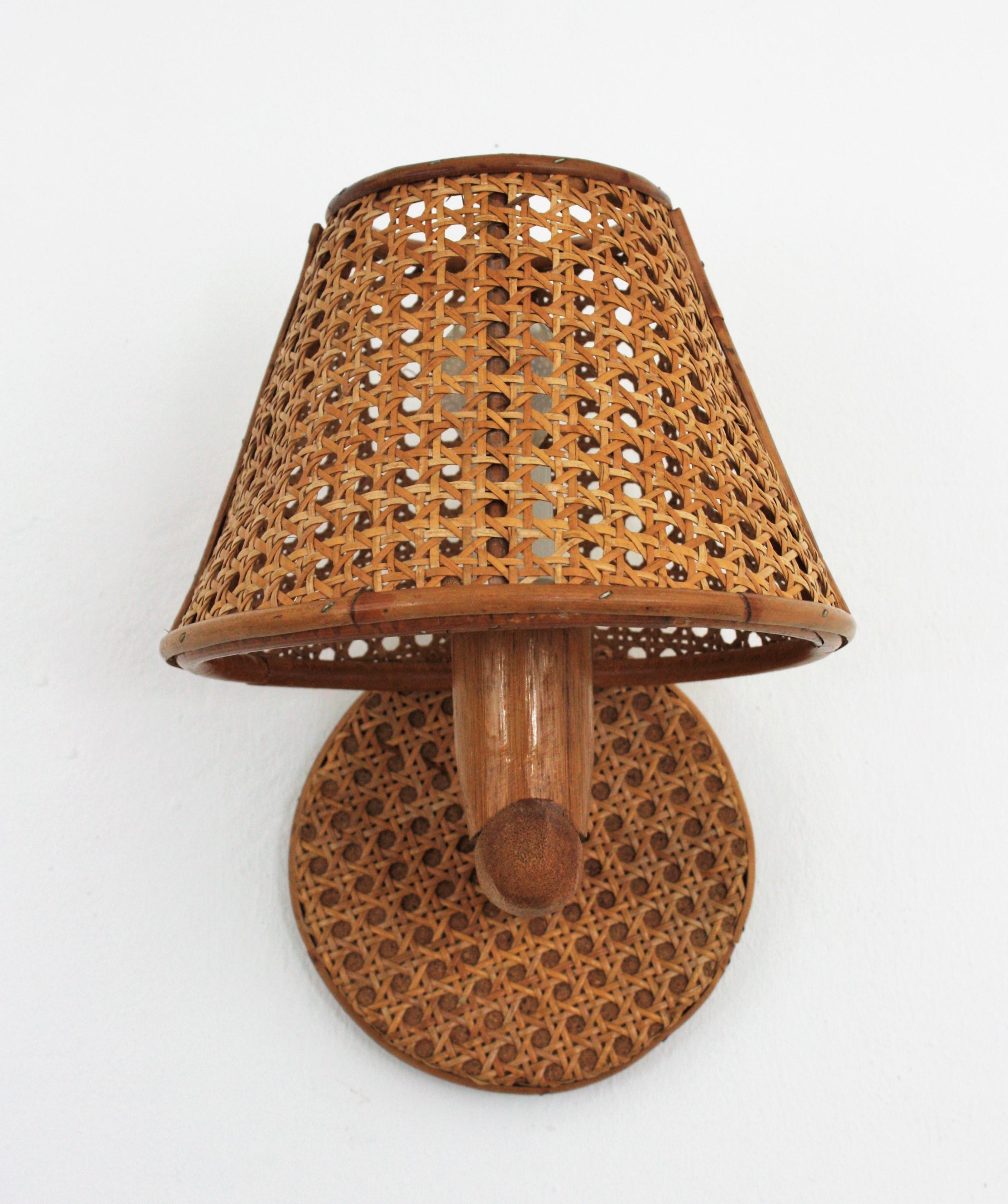 Eye-catching Mid-Century Modern wicker and bamboo wall light with wicker weave shade, Italy, 1960s.
This wall sconce features a round backplate covered with wicker wire holding a bamboo arm with a wicker wire lampshade.
It will be the perfect