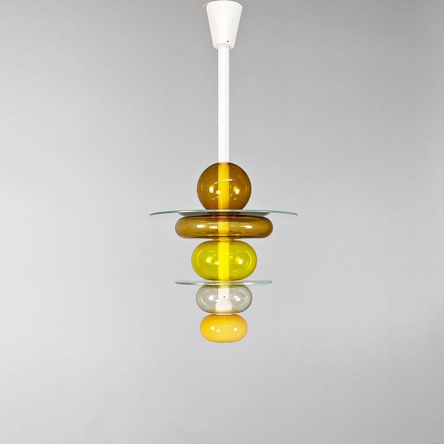 Italian modern yellow glass chandelier Firenze, Ettore Sottsass for Venini, 1990.
Florence model chandelier composed of a series of transparent and yellow glass spheres of different shades, interspersed with round glass discs. The supporting