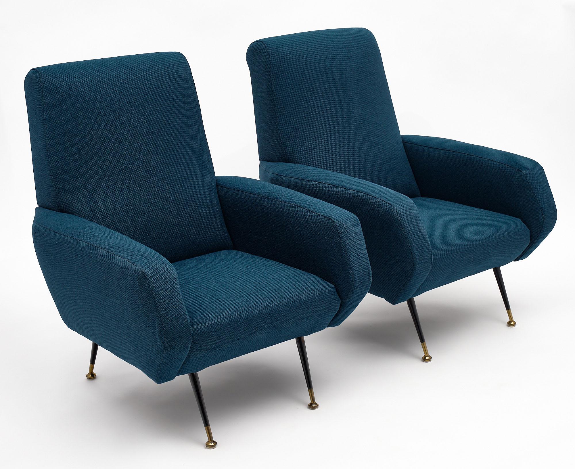 Italian modernist armchairs with lacquered brass legs and solid brass feet. This pair has strong lines and has been newly upholstered in a blue wool blend mix.