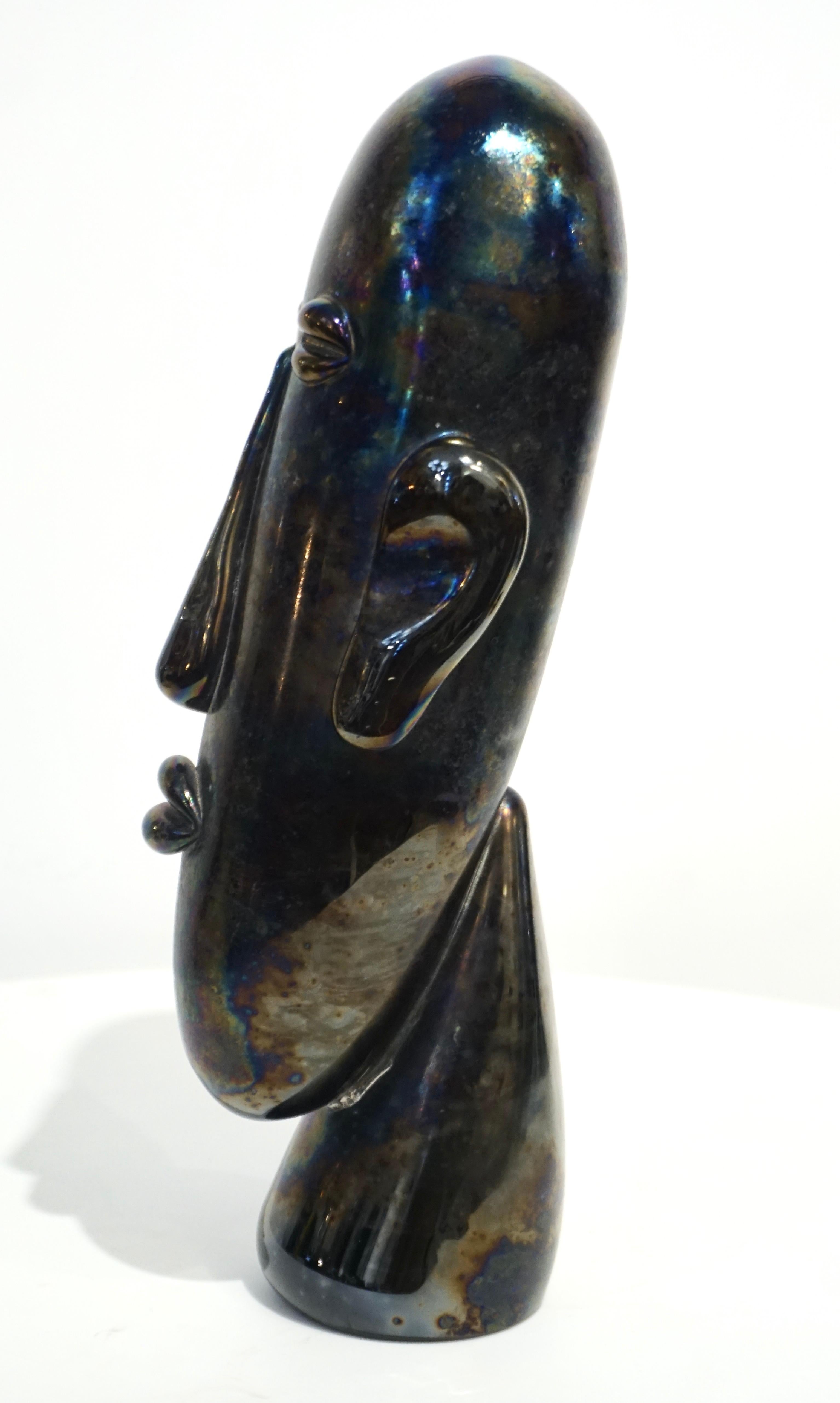 Amazing modern head in an ethnic design inspired by the Easter Island statues, very expressive mouth-blown sculpture in black Murano glass worked with an iridescent finish that adds depth to the realistic Work of Art, perfectly raised on a neck