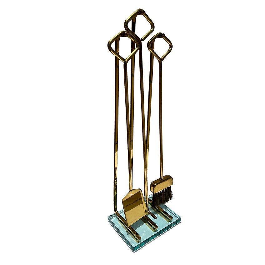Elegante juego moderno de herramientas para chimenea de Fontana Arte, alrededor de la década de 1970. El set incluye una pala, un atizador y una escoba. Cerdas de latón originales en una escoba. El juego está forjado en latón, y cada empuñadura