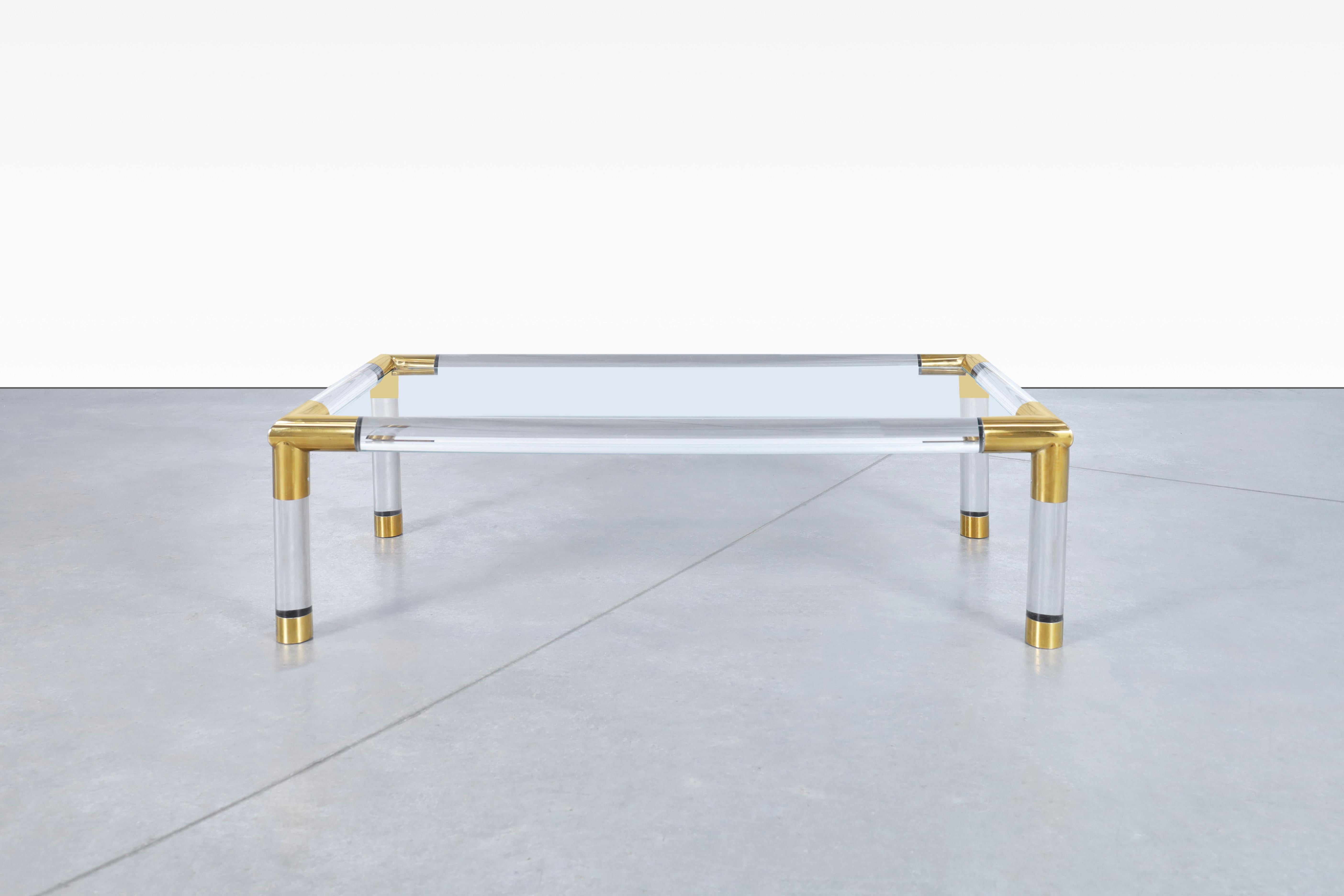 Exceptionnelle table basse moderniste italienne en laiton et lucite, conçue et fabriquée en Italie, vers les années 1970. Cette table exquise est un véritable chef-d'œuvre de l'artisanat italien. Elle présente une structure solide composée de tubes