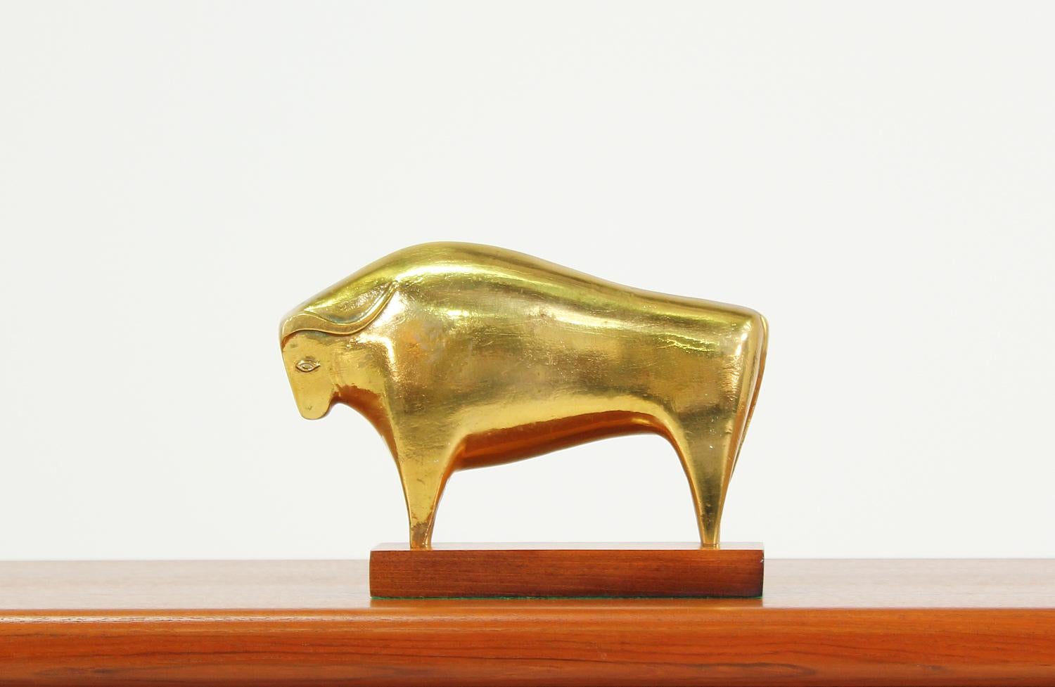 Vintage modernist bull sculpture manufactured in Italy circa 1950’s. This Mid-Century decorative art sculpture features a walnut wood base that supports a bull figurine comprised of brass. The metal shows a beautiful patina consistent with its age.