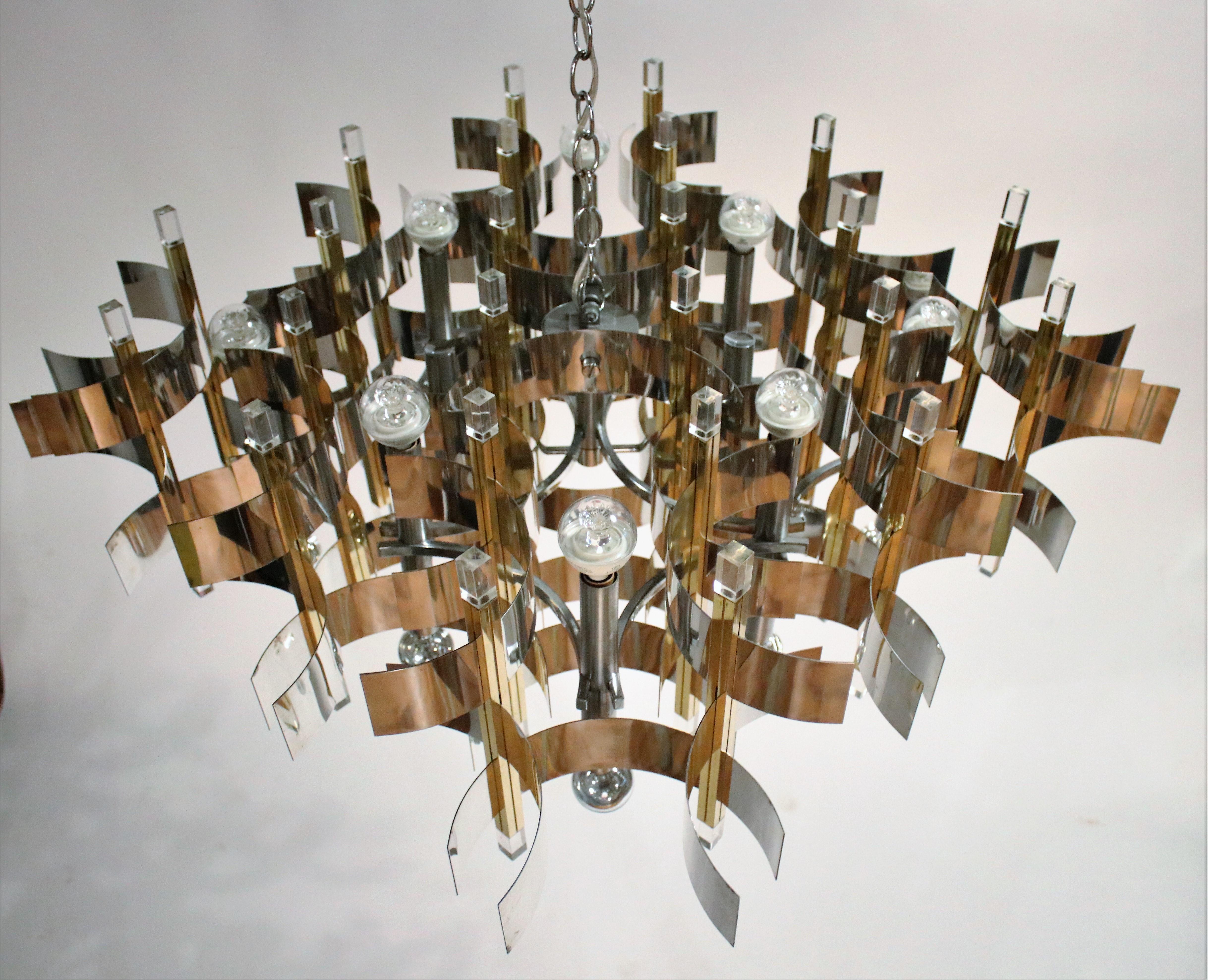 Massive Modernist chandelier by Italian designer Gaetano Sciolari, 1970s. Made of nickel and brass curved bands and rods with Lucite caps. Huge fixture with 24 total sockets sprouting from the top and bottom. Very clean vintage piece recently