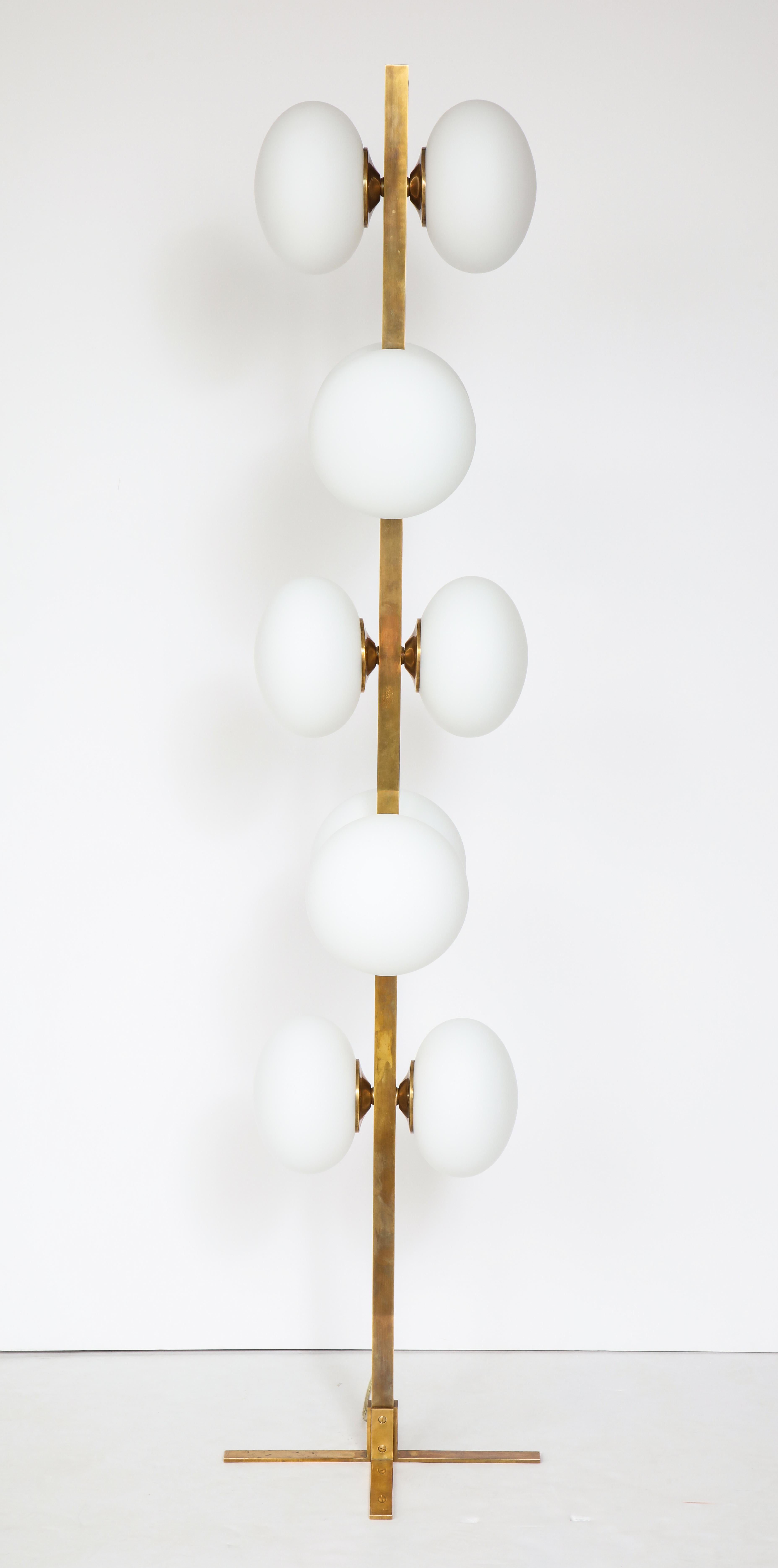 Italian modernist brass floor lamp with ten opaque glass globe lights , supported on an X form base. A striking and dramatic sculptural piece which would add great interest in any room. 
Italy, late 20th century
Size: 72 1/2