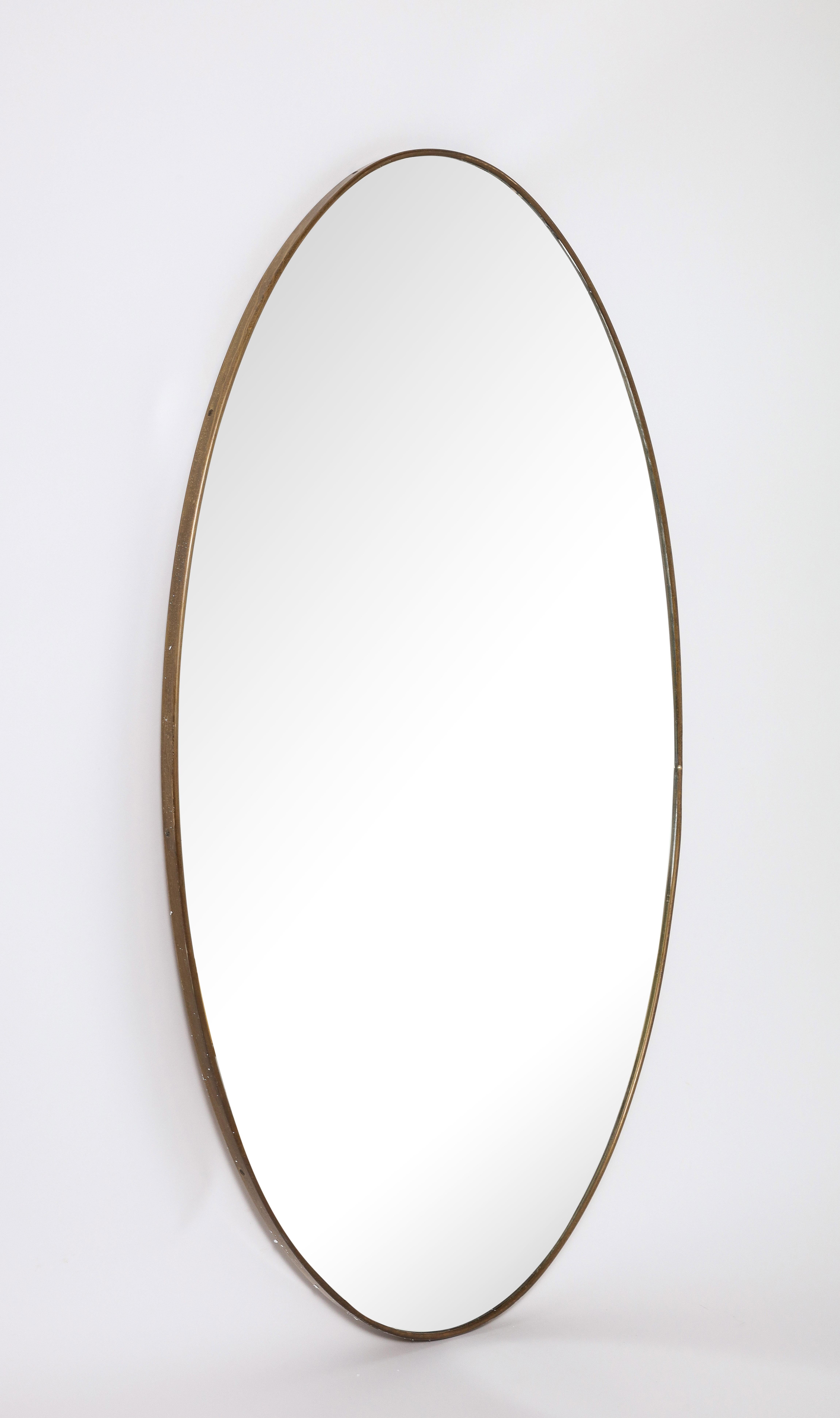 Ovaler Messingspiegel im italienischen Modernismus; eine wunderbare Form, das Messing mit originaler warmer und reicher Patina. Original Spiegelglasplatte. 
Italien, um 1950 
Größe: 49