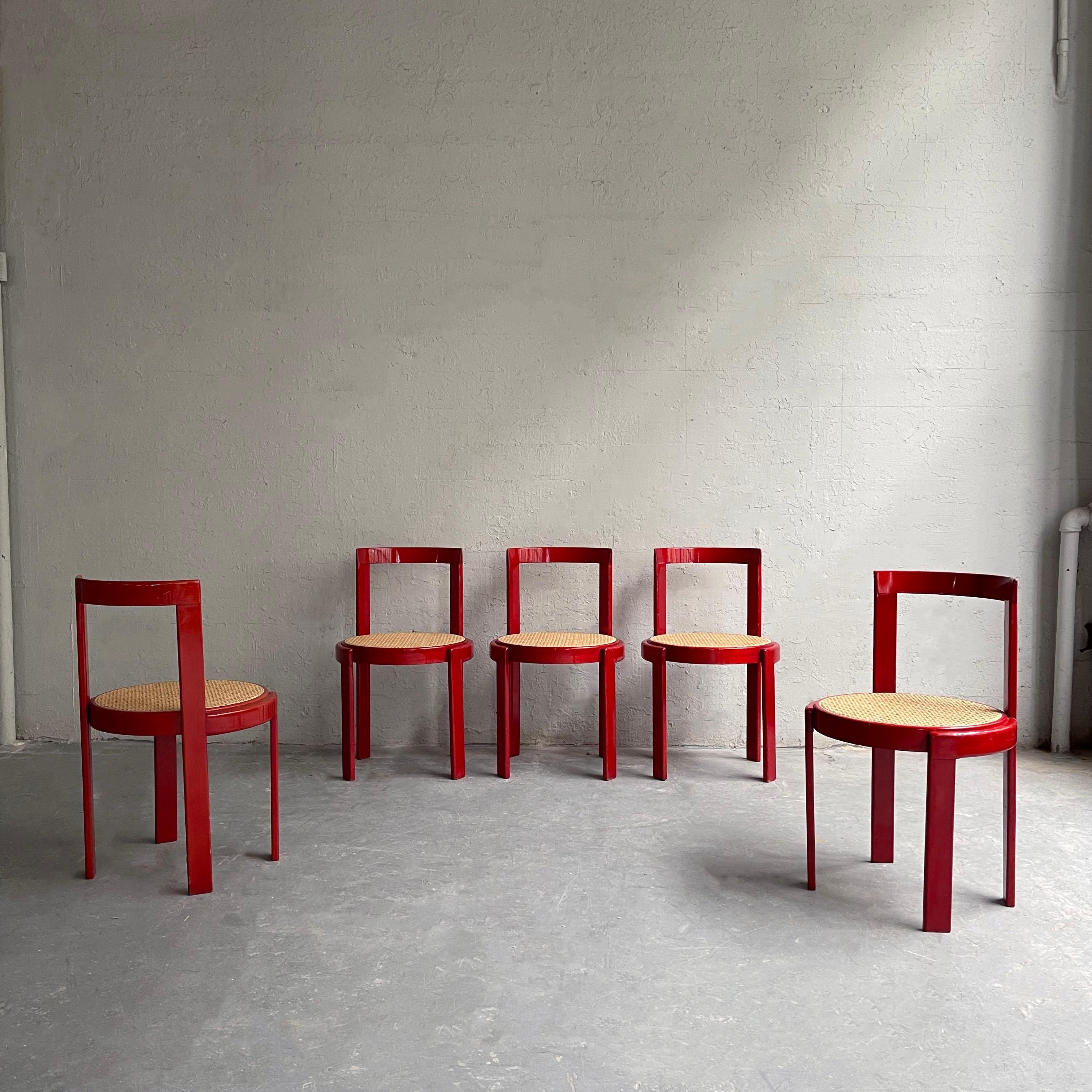 Set of six, Italian modernist dining chairs feature circular, lipstick red stained beech frames with natural caned seats. This is a set of six chairs, five are shown.
