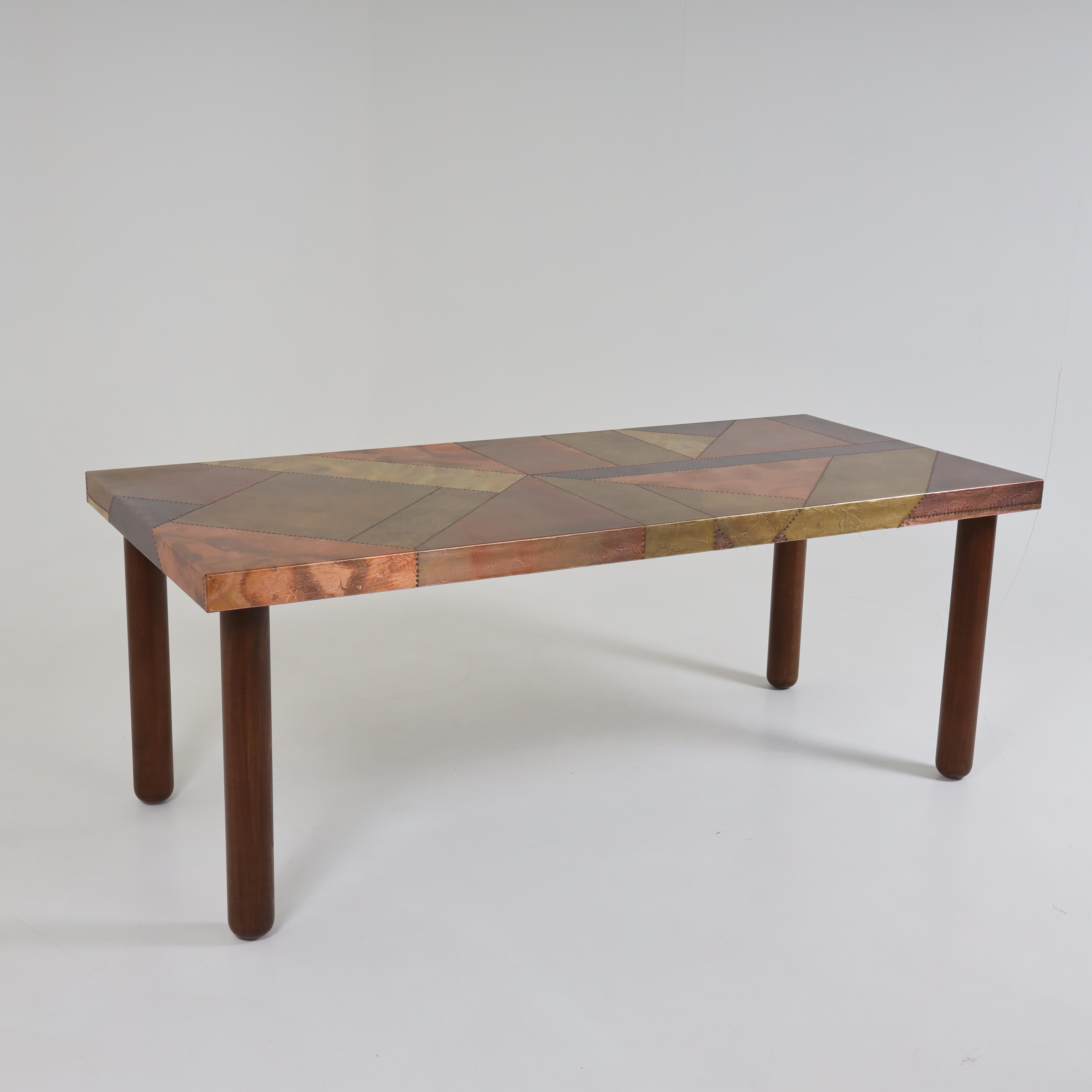 Italian Modernist dining table by Lorenzo Burchiellaro Wooden legs 
and shelves made of hammered and riveted metal surfaces in
geometric patterns. Laterally stamped 