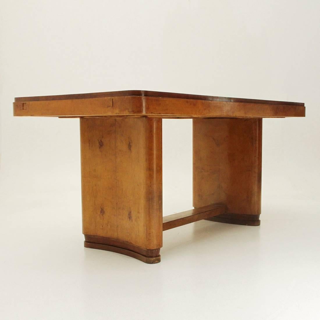 1940s table of Italian manufacture.
Structure formed by two half-moon shaped bases in wood veneered in briarwood joined by a wooden partition.
Rectangular top with rounded corners in veneered wood.
Telescopic rods to extend the plan. Extensions
