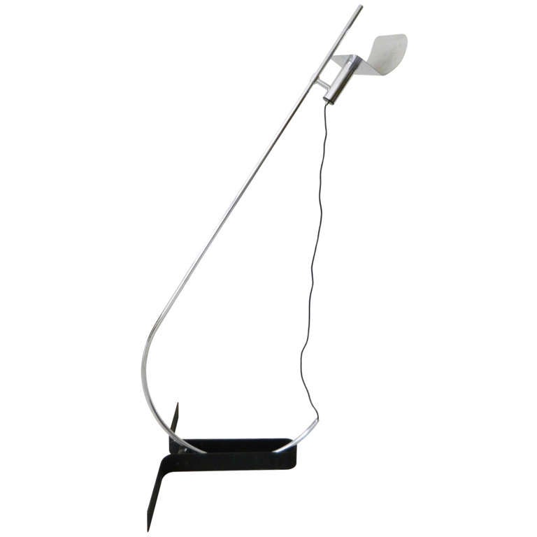 Substantial high quality chrome floor lamp with black lacquered metal base by Ennio Chiggio for Lumenform. The shade moves up and down so the shade height is regulatable.