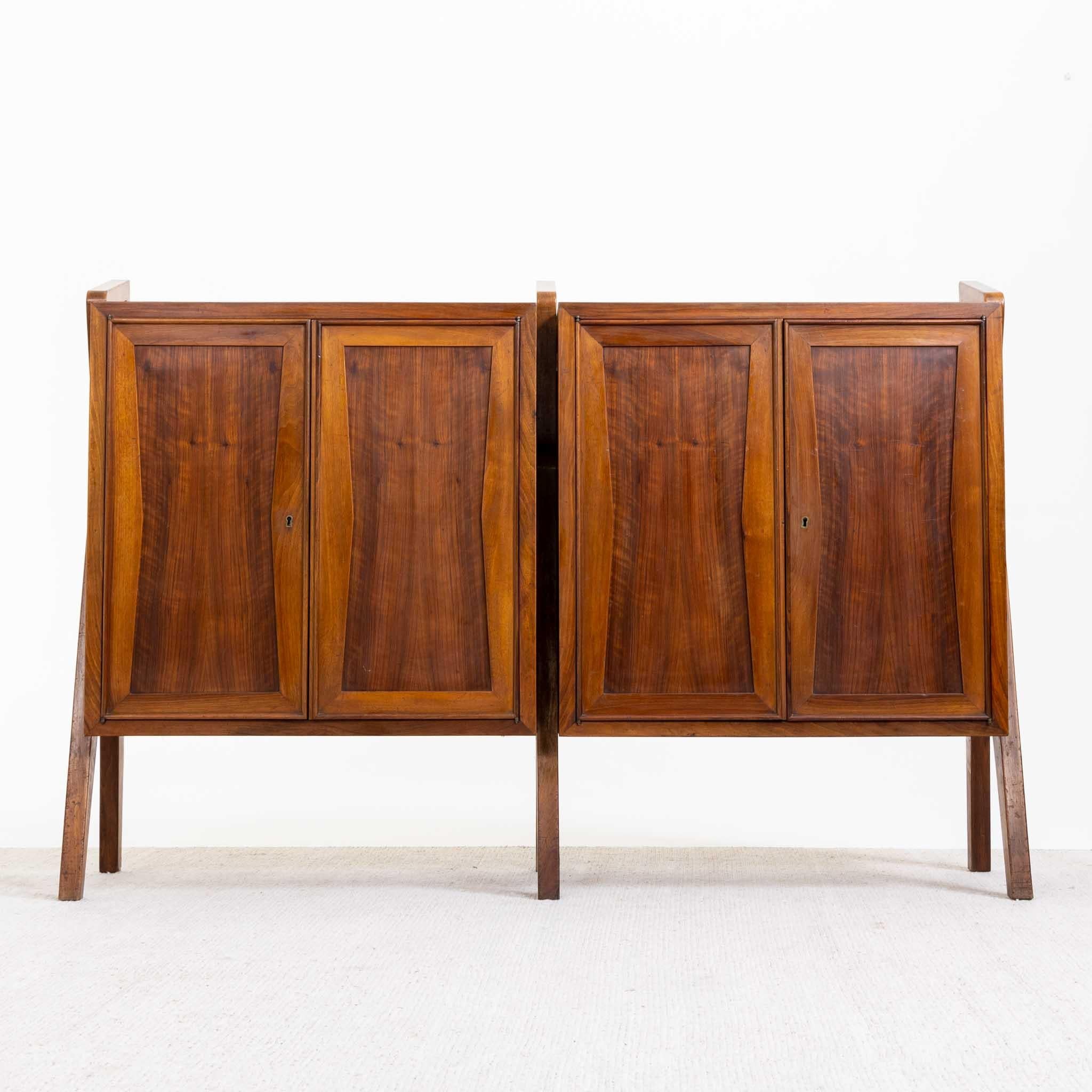 Italian mid-century sideboard or cabinet with four doors. The cabinet is made of walnut and mounted on three sculptural leg supports. The sideboard has been polished by hand and has a beautiful veneer pattern on the front.