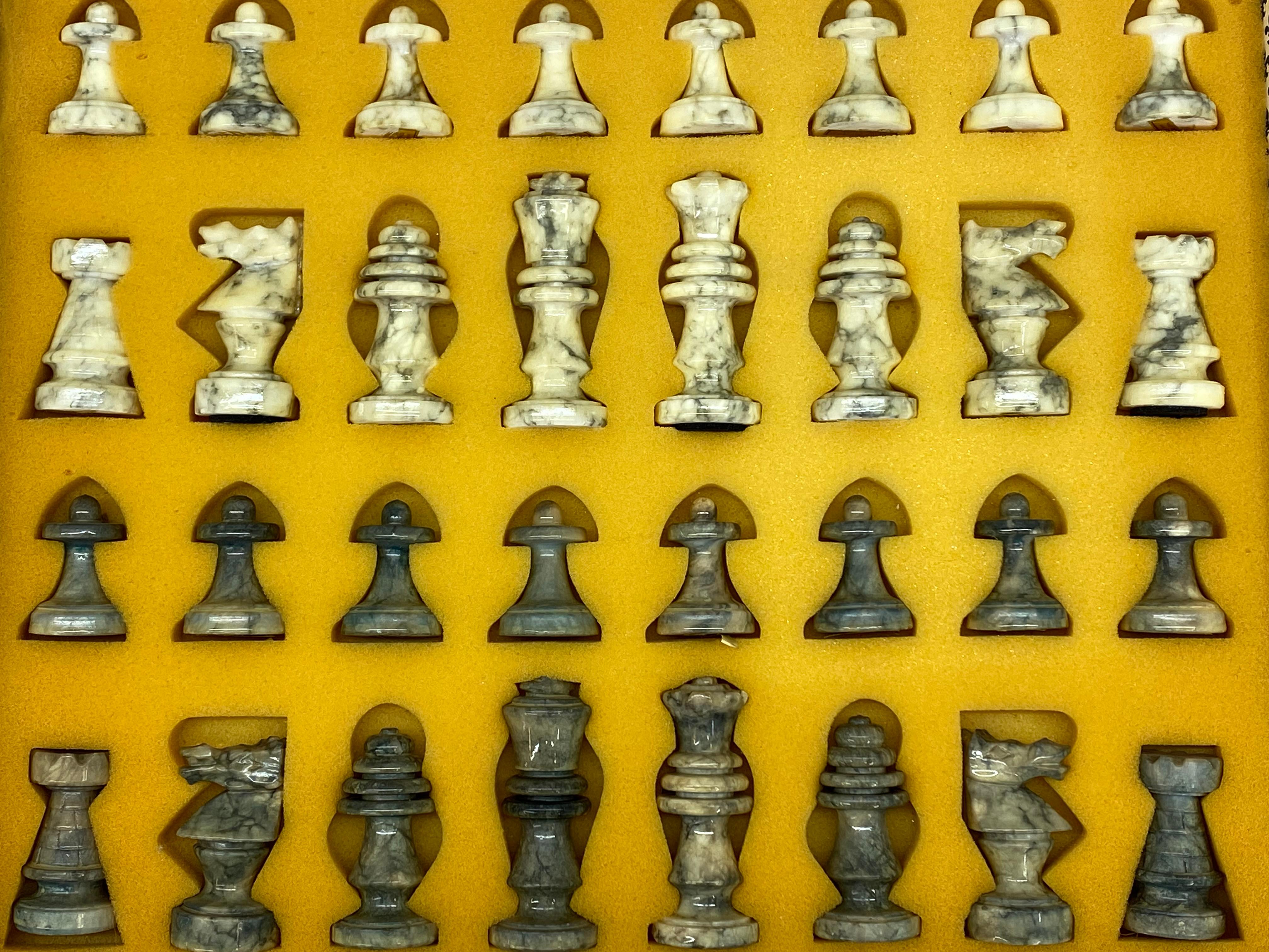 A complete set of Italian modernist hand carved chess figures. These marble chessmen were fastidiously carved, hand polished and lacquered. The white marble pieces have gray veining and the gray marble pieces have a dark gray veining. Some pieces