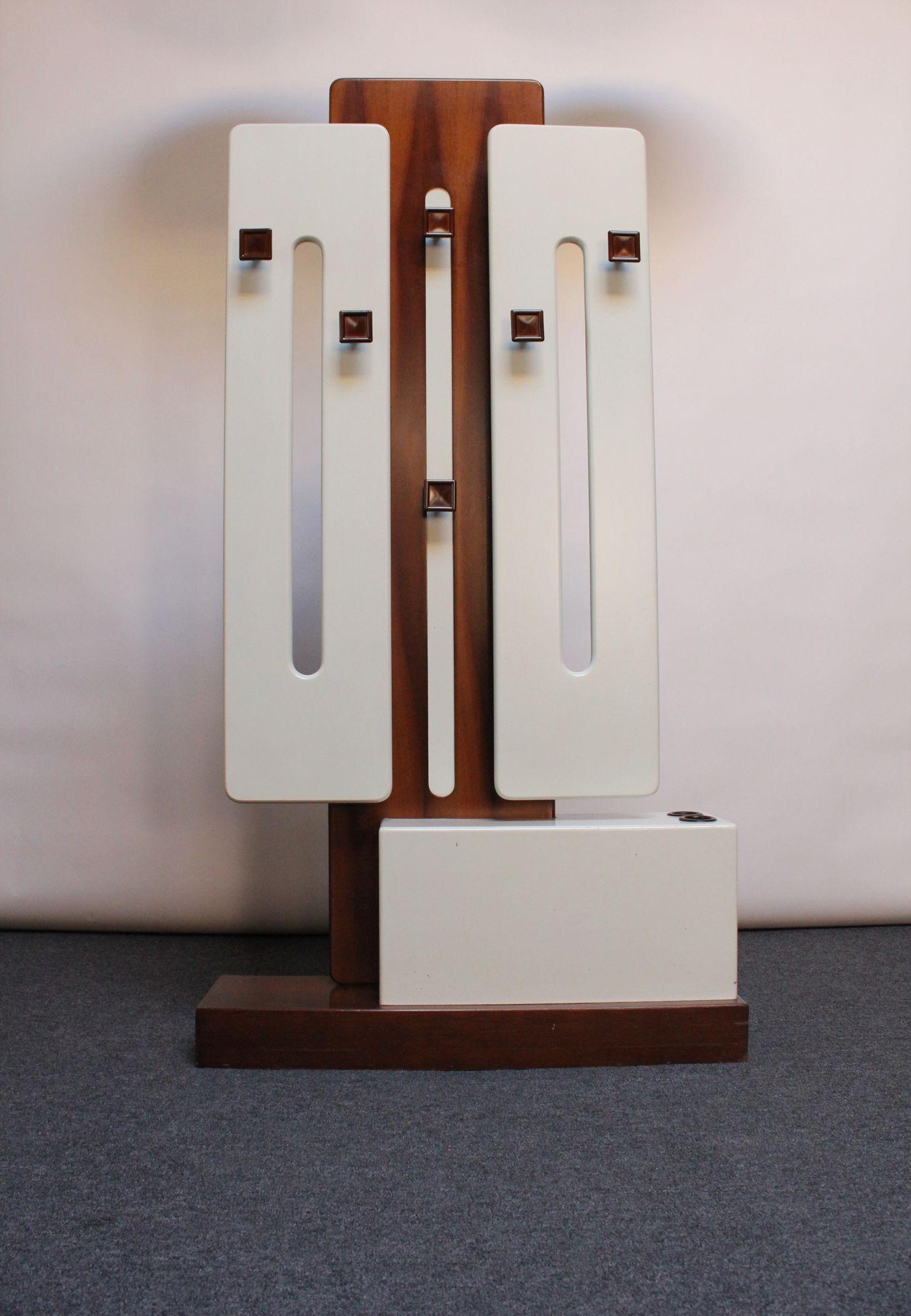 Luigi Sormani coat stand in lacquered walnut veneer, plastic, and laminate components (ca. 1970s, Italy). Composed of white laminate folding doors with plastic hooks on both sides supported by a dual-umbrella holder and lacquered walnut veneer