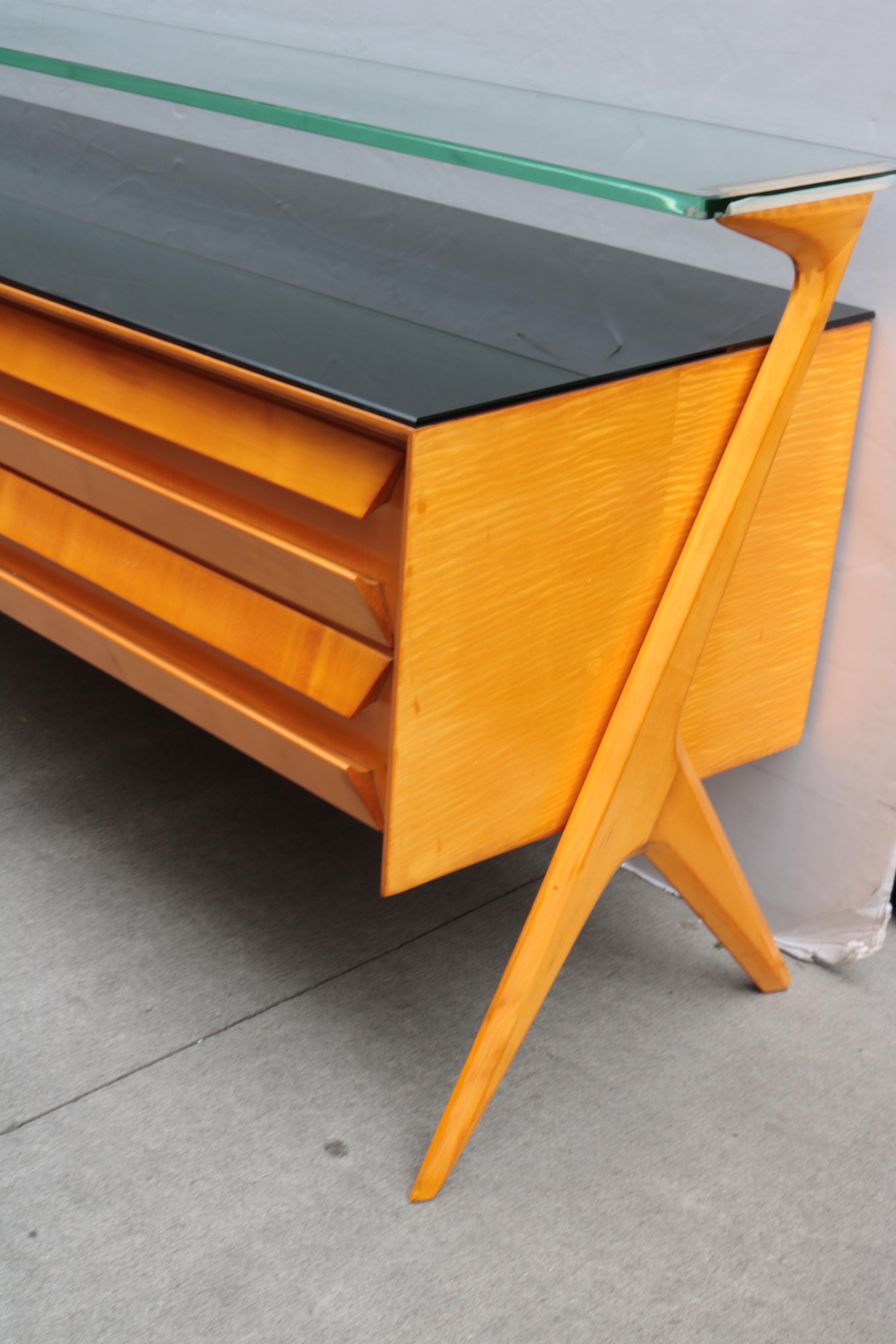 An Italian modernist low sideboard.
Sycamore with black glass and clear glass surfaces.
 