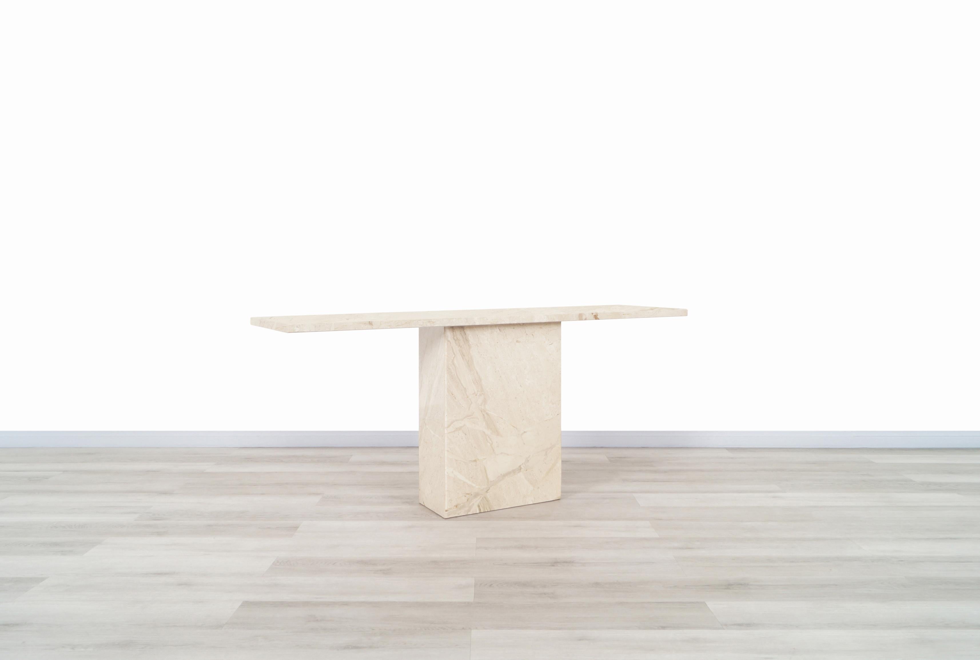 A stunning vintage marble console table designed and manufactured in Italy. The modernist design is perfectly complemented by the natural grain. The table features a gorgeous rectangular marble top that sits over an extremely sturdy marble base. Its