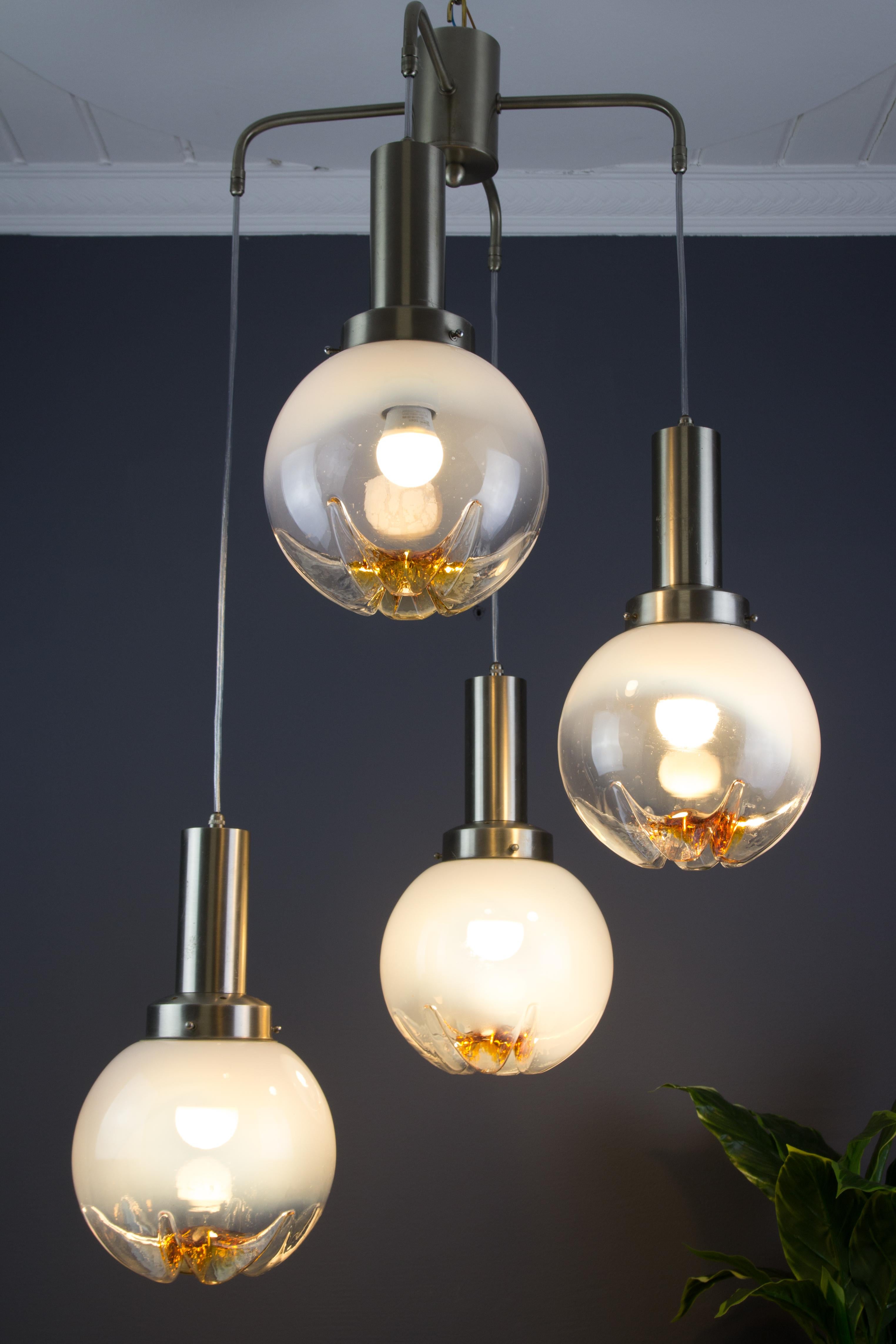 The spectacular Italian pendant chandelier features four large Murano art glass suspension lights in clear and orange on a steel frame. Four sockets for the E27 (E26) size light bulb.
Dimensions: height 95 cm / 37.4 in; width 50 cm / 19.68 in; depth