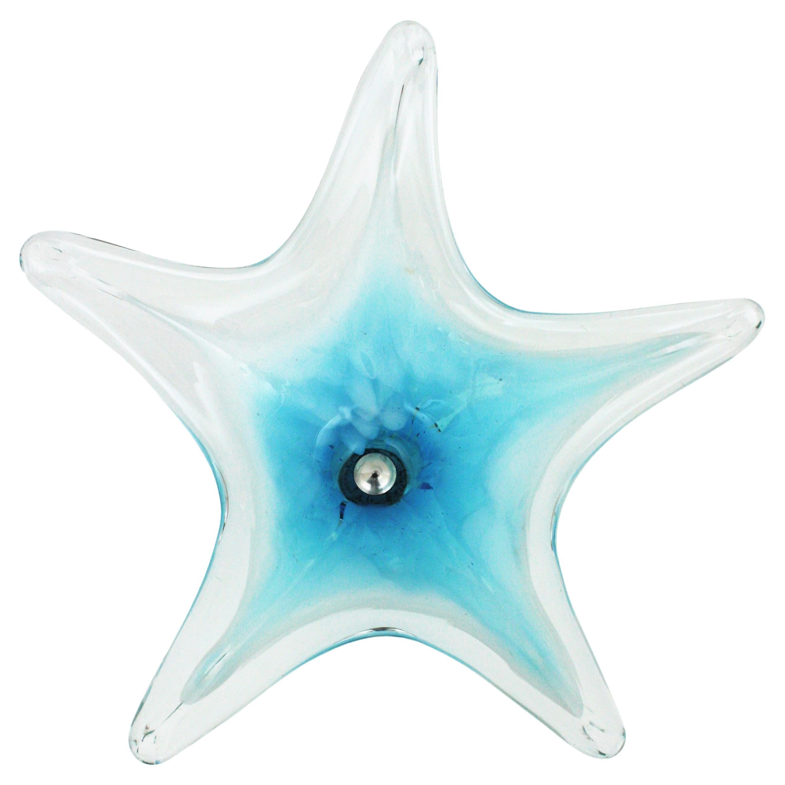 Vase centre de table en verre soufflé bleu et blanc de Murano, de style moderniste du milieu du siècle dernier. Italie, années 1960.
Il a une couleur qui attire l'attention et un design organique très décoratif en forme d'étoile. Le centre de table