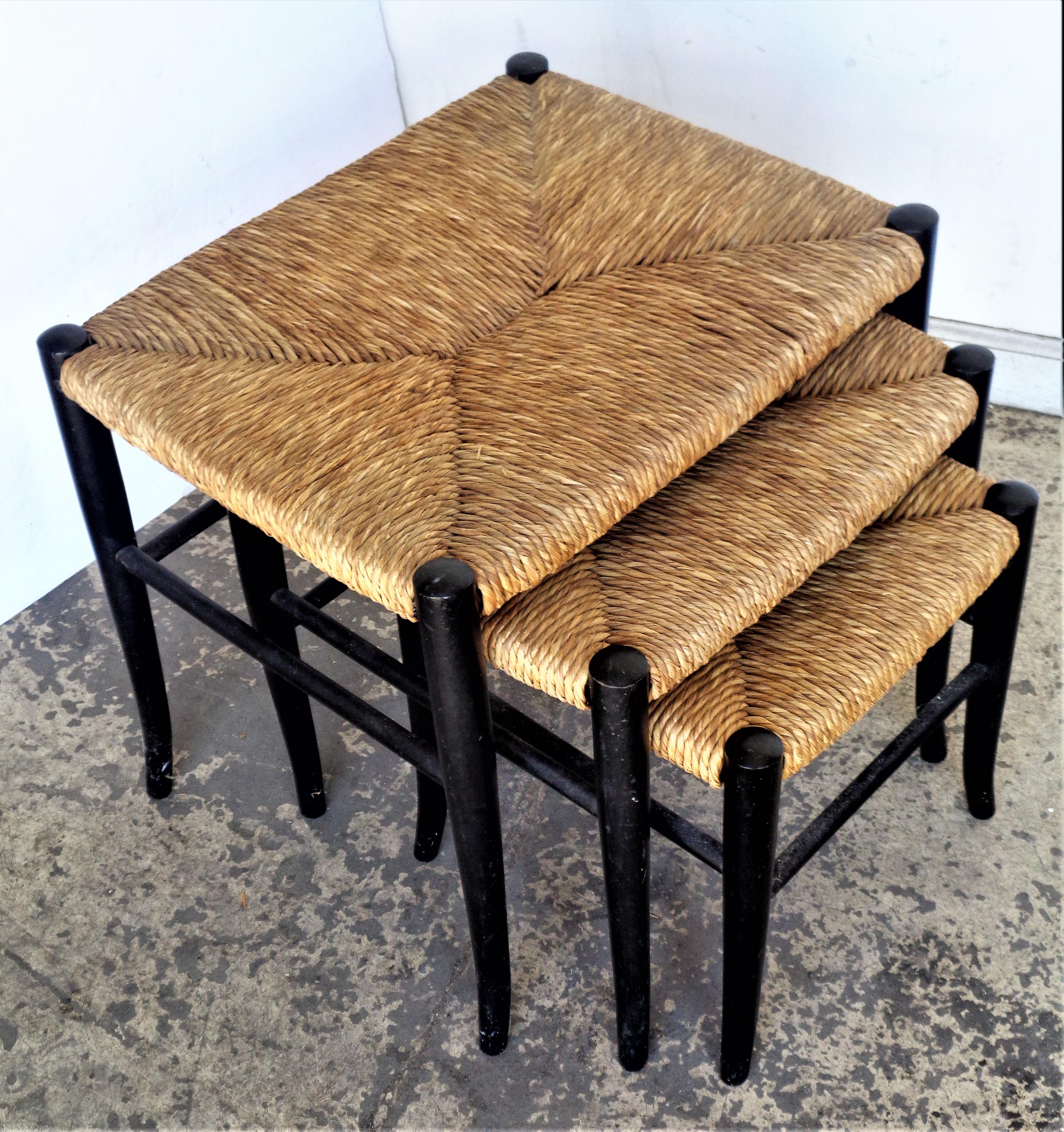 A set of three graduated size nesting stools with the original ebonized wood frameworks and handwoven rush seats in overall beautifully aged structurally solid original condition. Style of Gio Ponti, circa 1960. Small stool stamped Italy small.