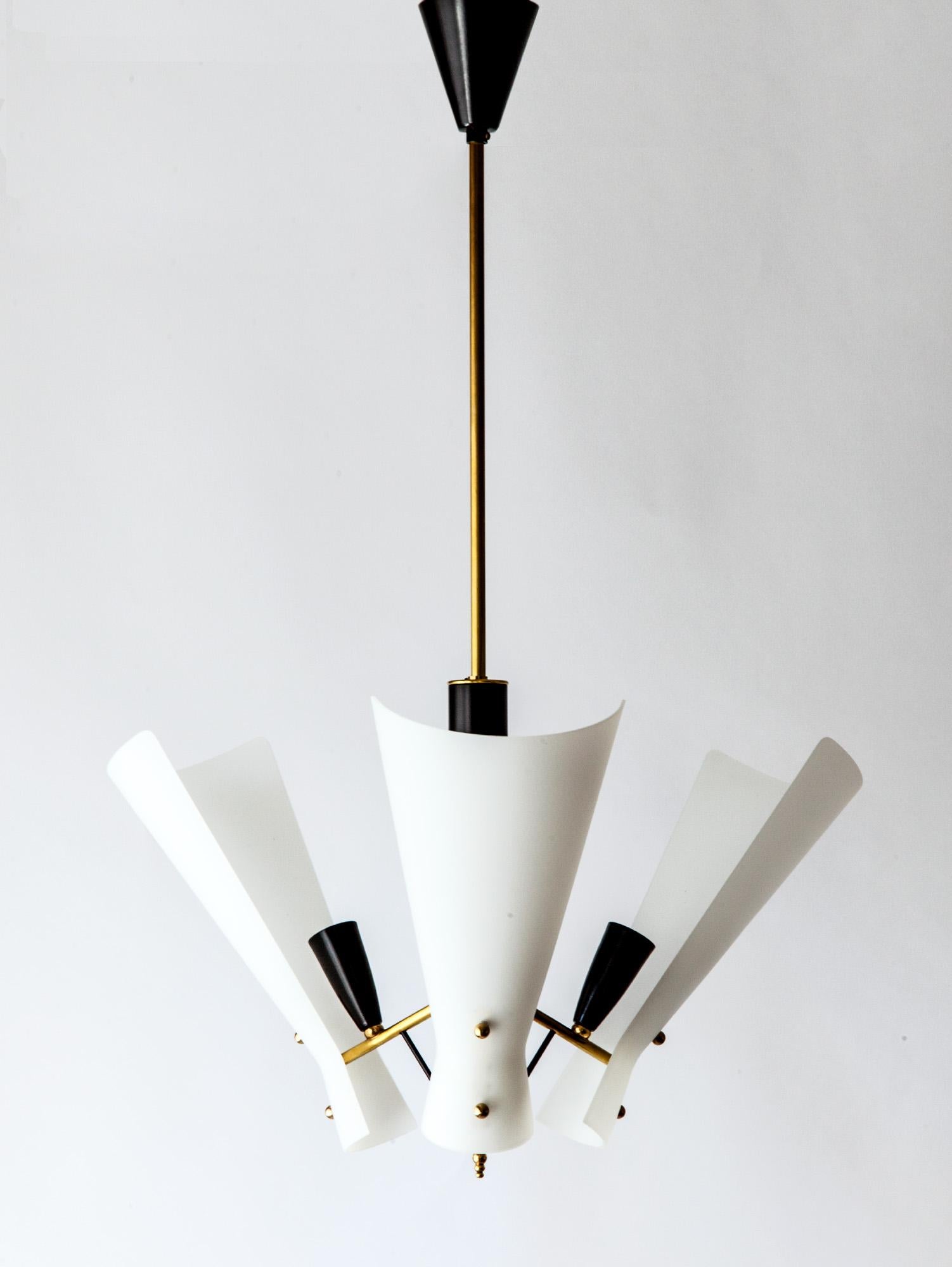 A stunning vintage Italian modernist ceiling light. The white soft milky glass panels contrast against the brass and sharp black details. The angular shape of the glass panels are softened by its round form. Elegant in its design, the pendant