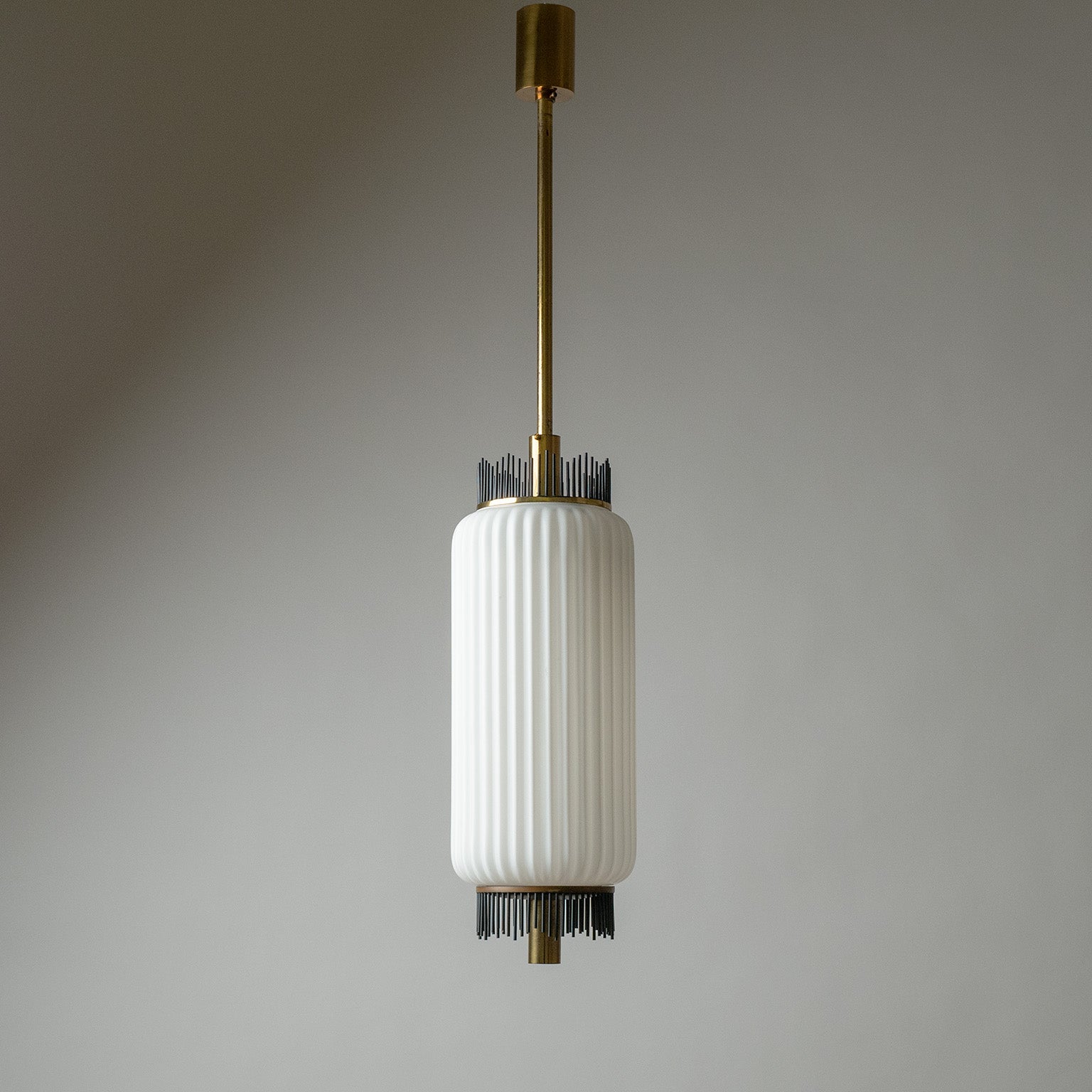 Rare modernist Italian pendant or ceiling light from the 1950s. Composed of a large ribbed satin glass diffuser and brass hardware with graphical black lacquered brass finials on both ends of the glass. Very nice original condition with some patina