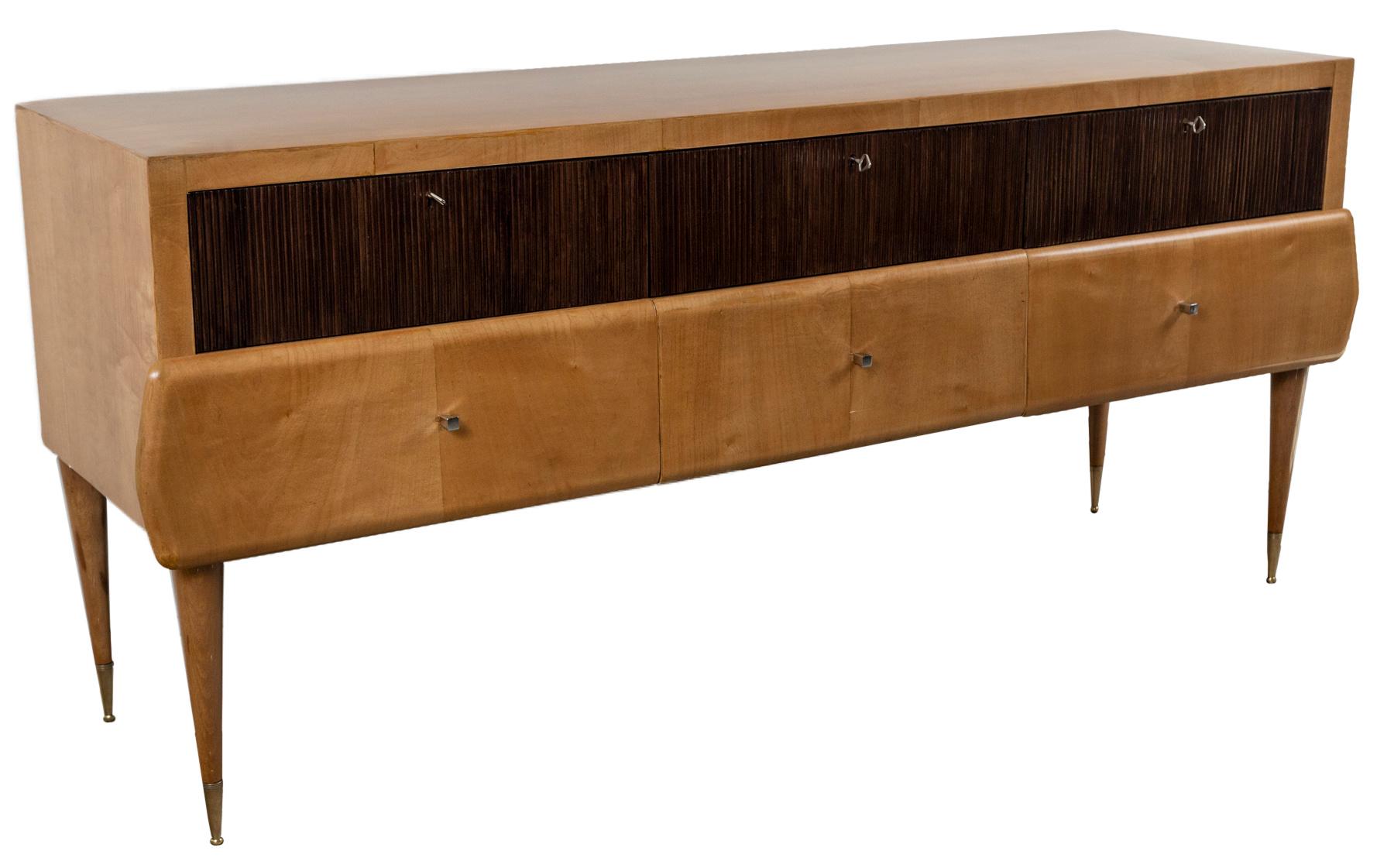 A unique maple sideboard composed of six drawers with the top three drawers adorned with reeded fronts in walnut and finishing in straight rounded and tapered legs with high brass sabots and shown with its original keys. Note overlapping modeled