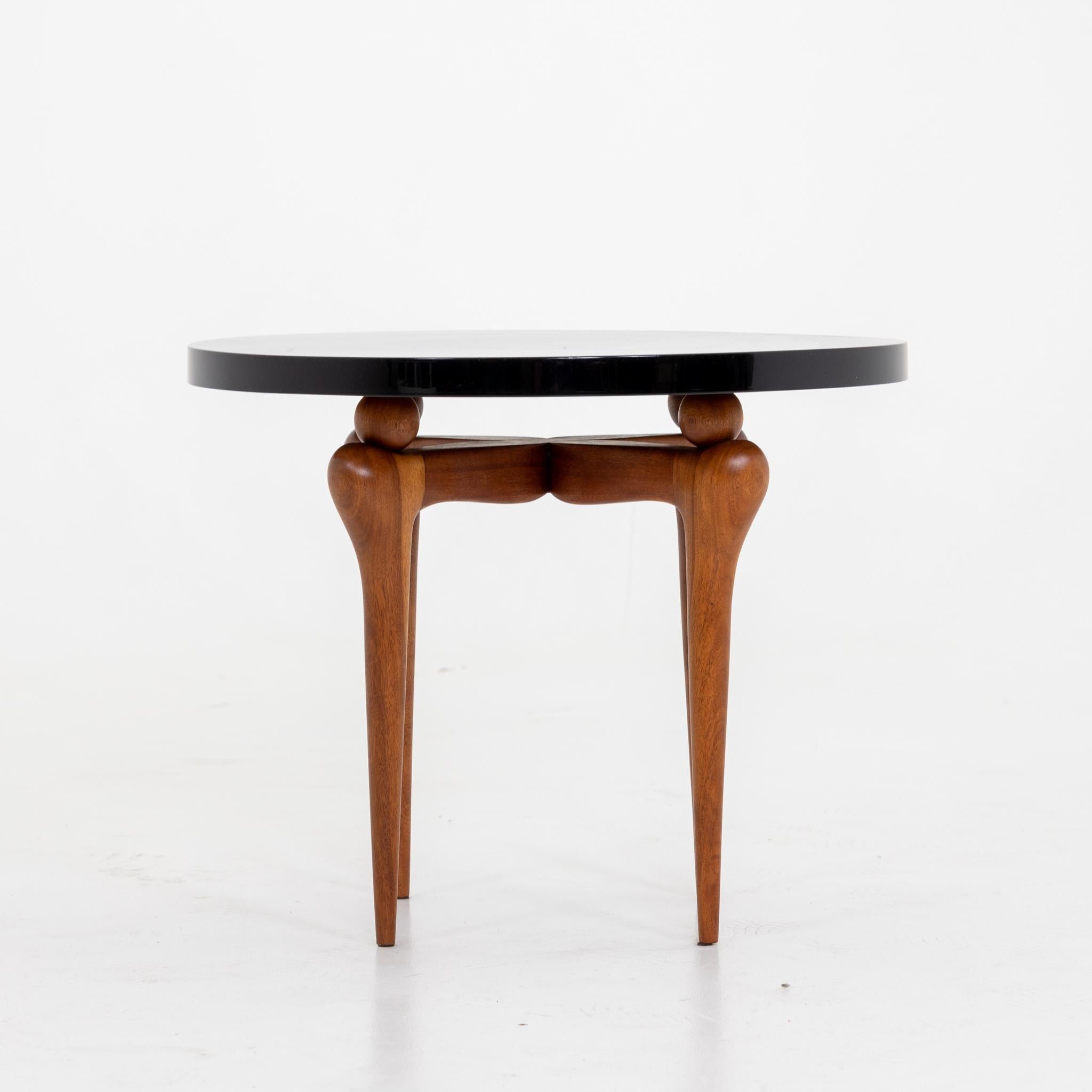An Italian Modernist small round side table. 
Black lacquer top with walnut legs.