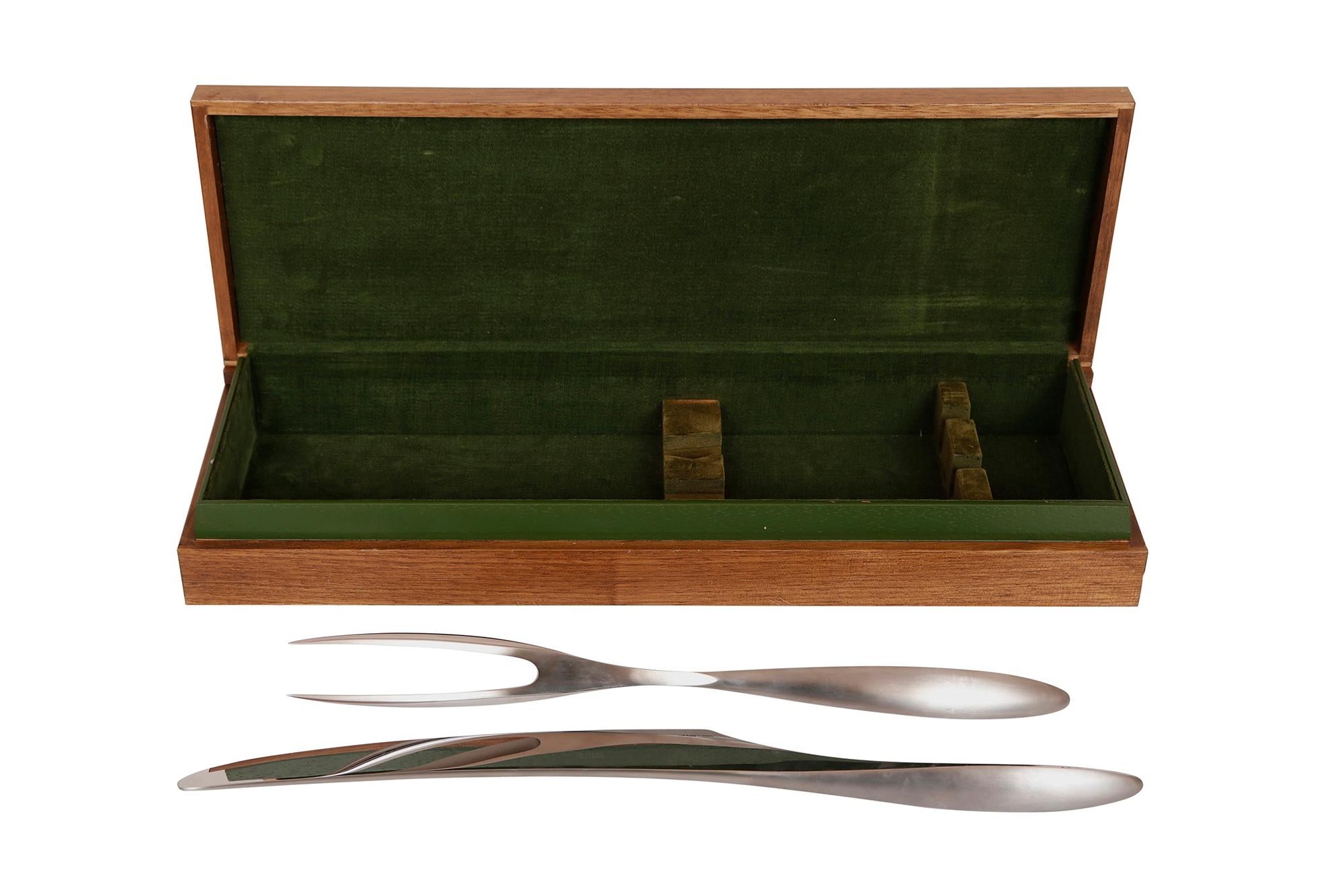 An Italian modernist stainless steel carving knife and fork set. Each is signed Chef P. Giovani and marked Stainless Steel, Italy, Pat. 85278 and Pat. 85279. Housed in a green velvet lined wooden box.