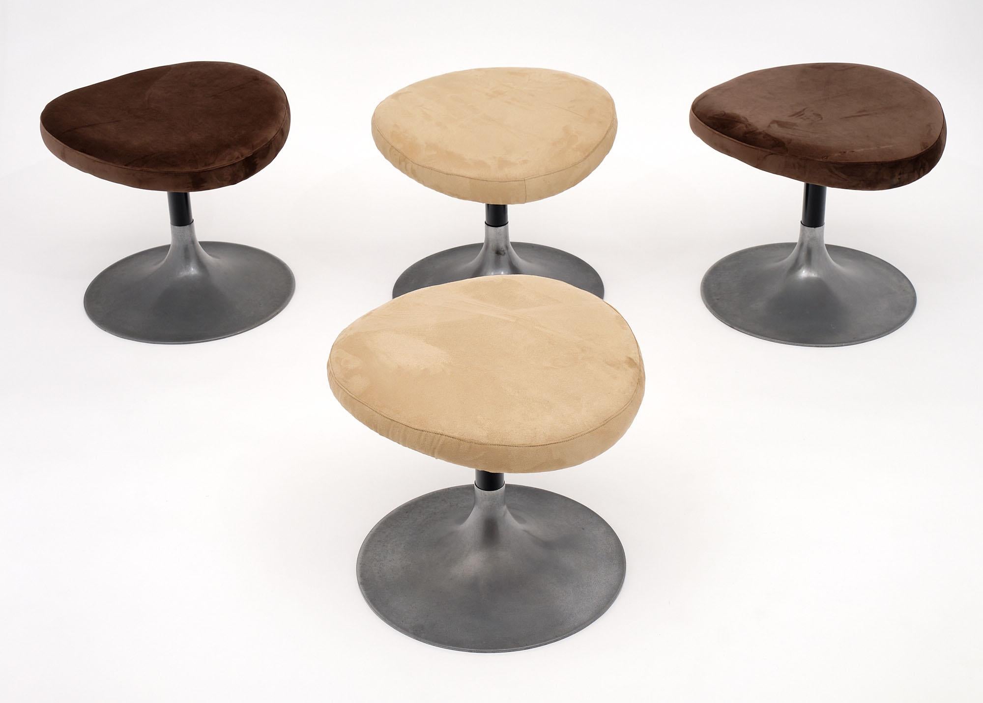 Set of four stools from Italy. Each modernist stool has a circular base of aluminum alloy. The curvilinear seat has been newly upholstered in a chocolate brown or cream tone.
     