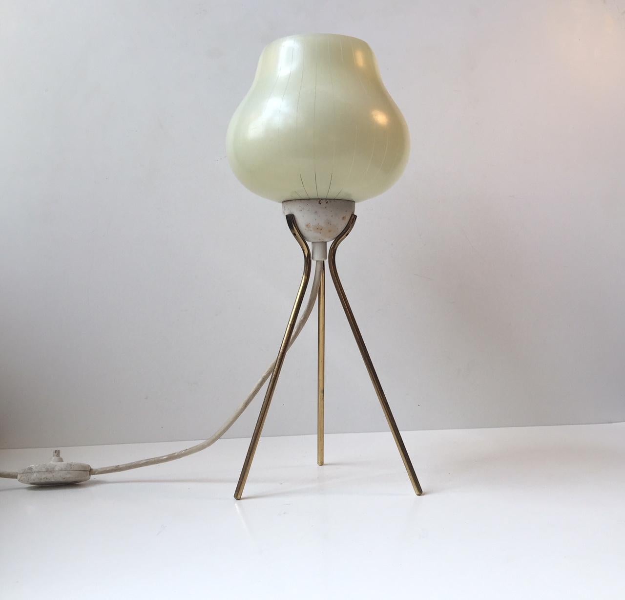Elegant tristand table or desk lamp with rounded of brass legs and pin-striped glass shade. It was manufactured in Italy during the late 1950s or early 1960s in a style reminiscent of T. H. Robsjohn-Gibbings.