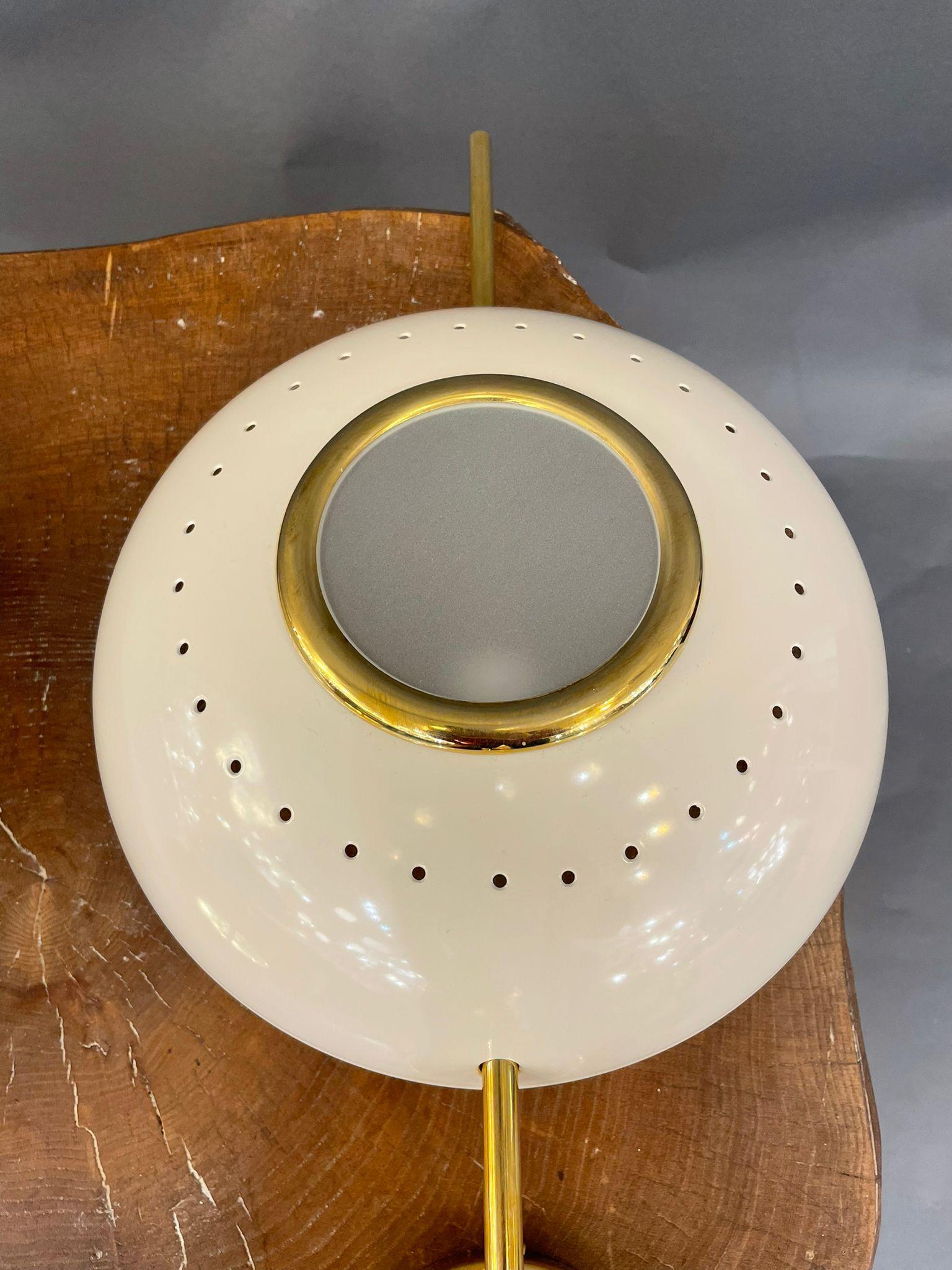 An elegant pair of Italian modernist wall lights executed in brass with ivory aluminium lens shades.