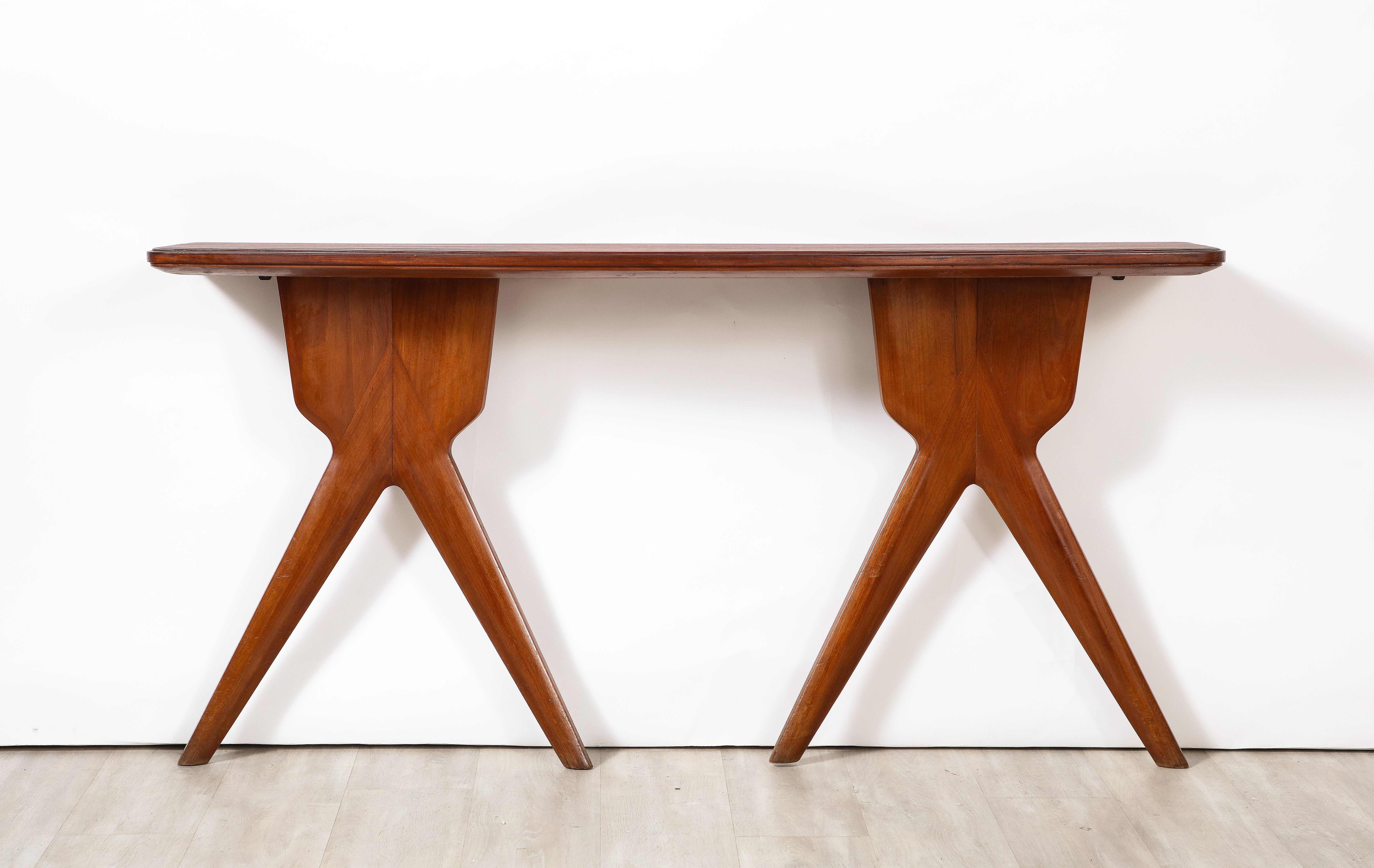 An Italian modernist walnut wall mounted console; the top is beautifully shaped and fluted and the two bases with wonderful splayed shapes.  A very unique design.
Italy, circa 1960 
Size: 31 1/2